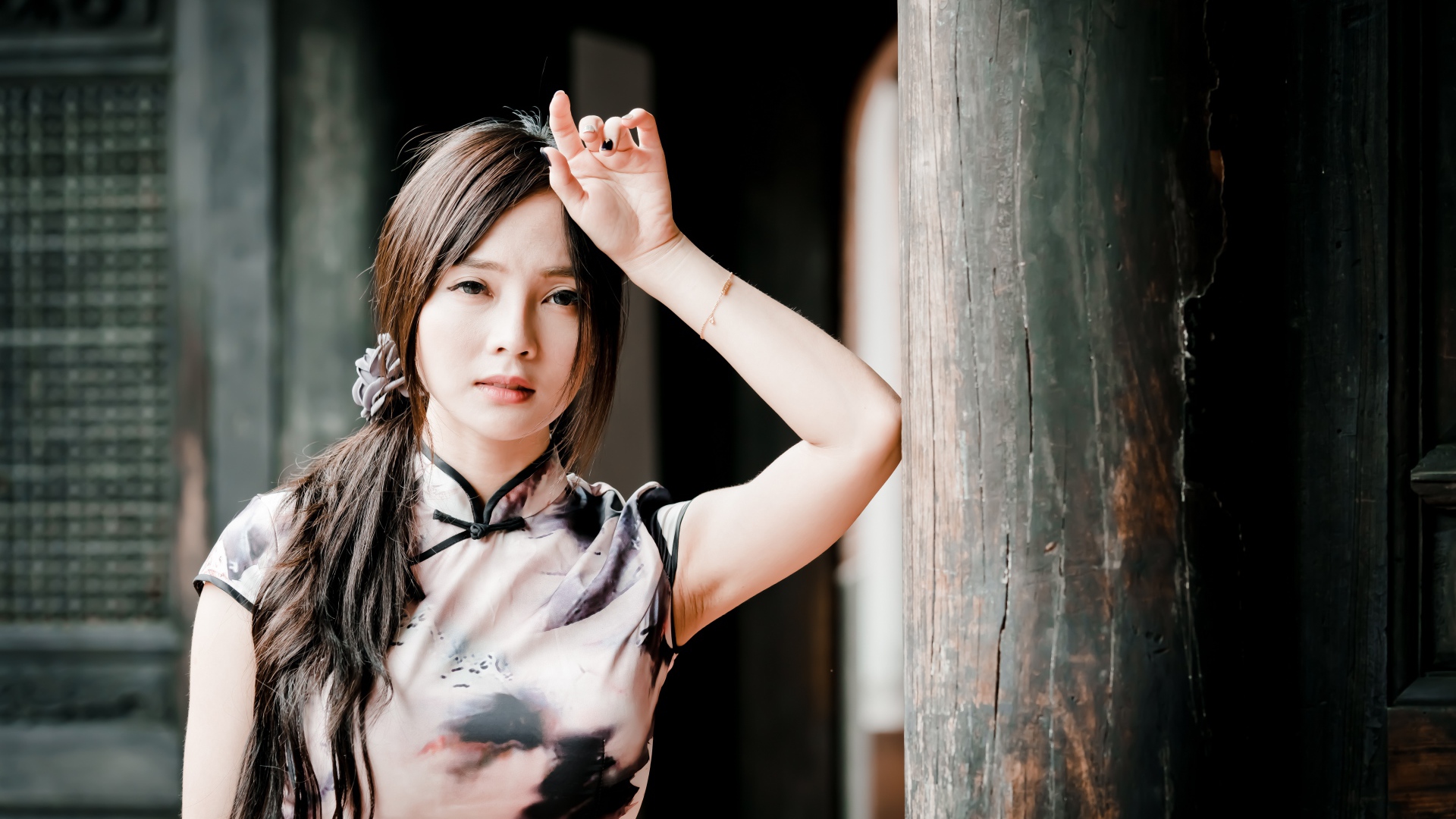 Молодая девушка азиатка стоит у столба 