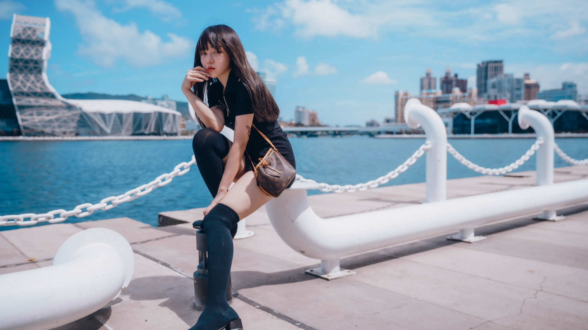 Молодая азиатка сидит в порту 