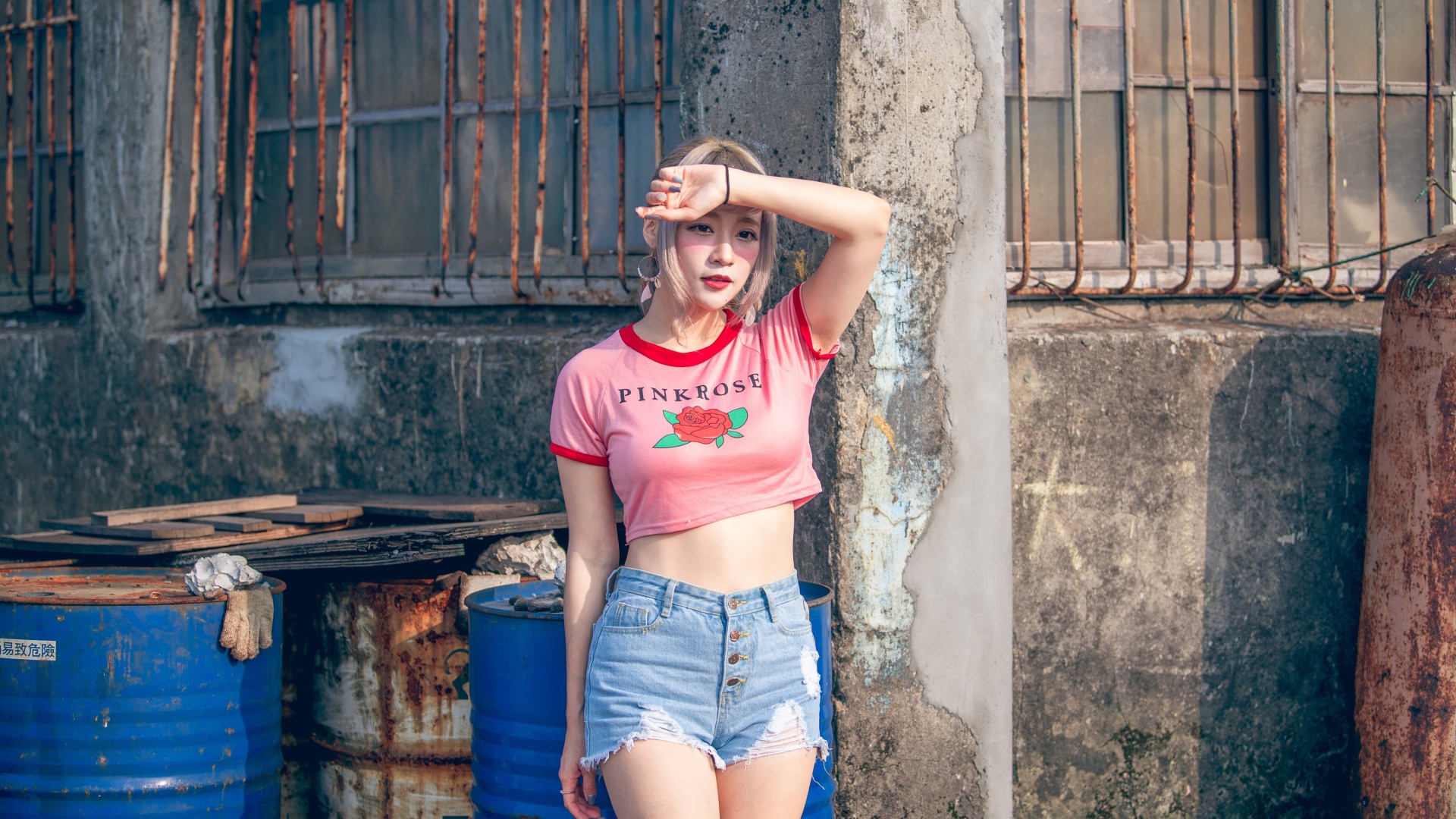 Молодая азиатка стоит у стены 