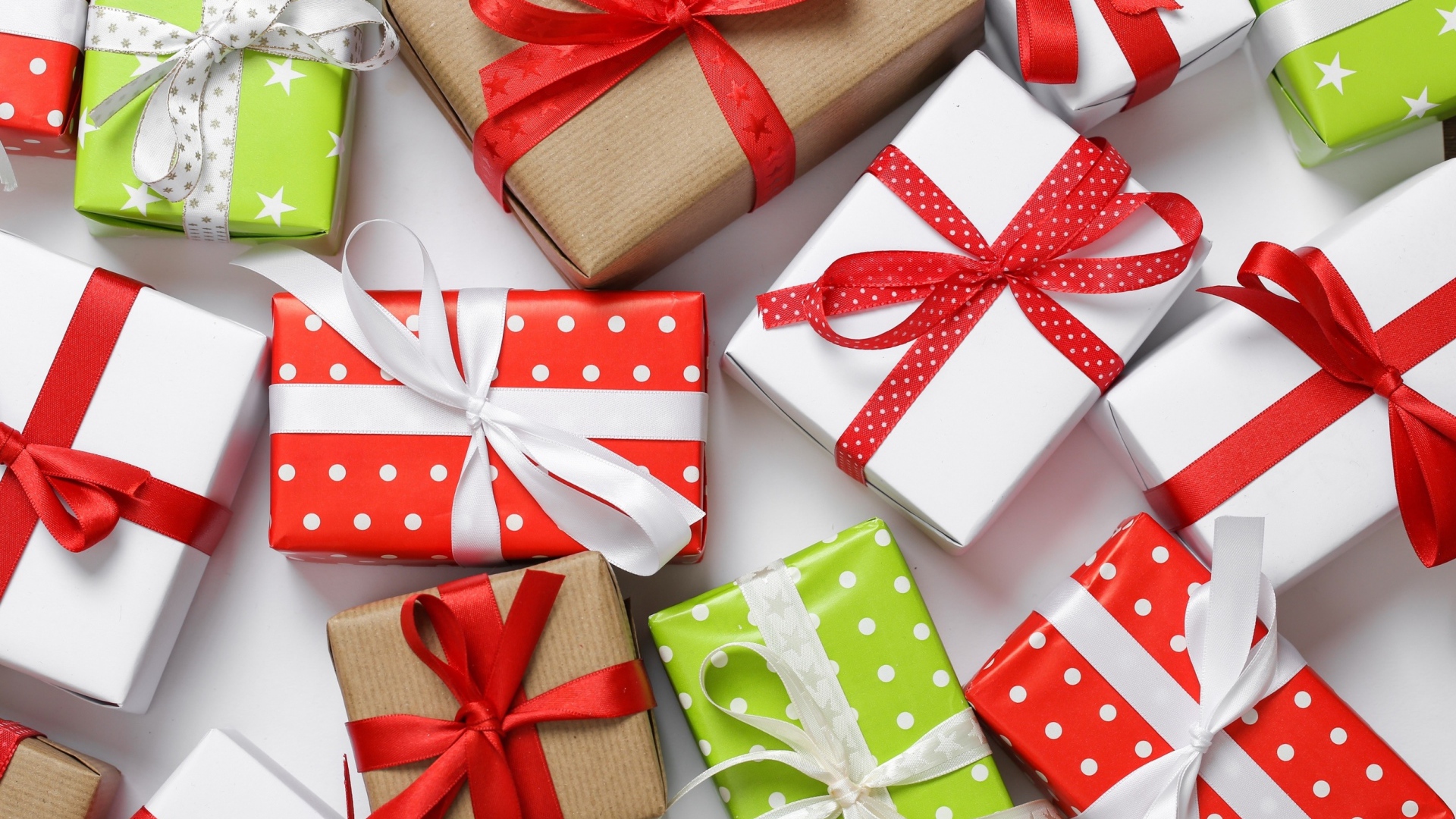 Разноцветные подарки на белом столе крупным планом 