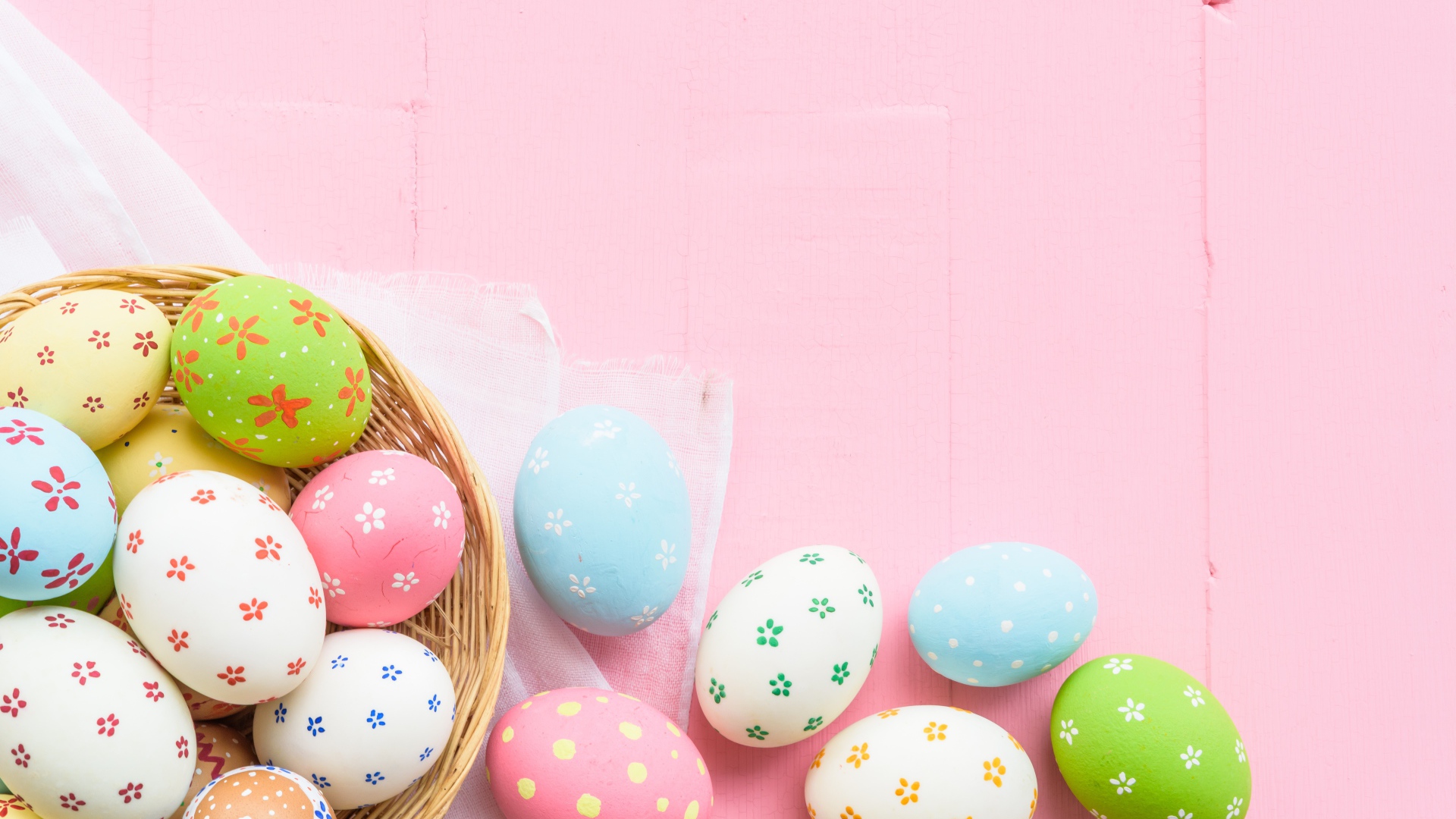 Разноцветные пасхальные яйца на розовом фоне