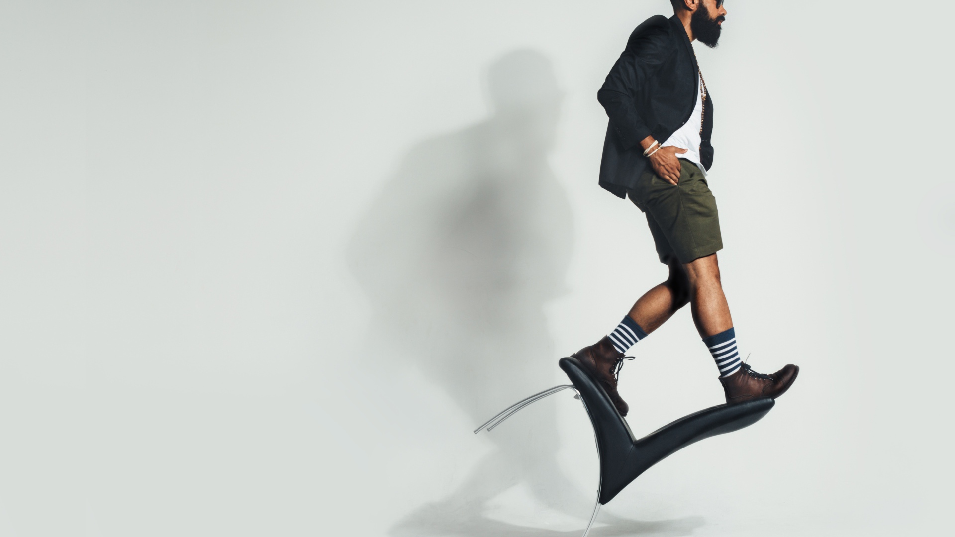 Мужчина балансирует на черном кресле