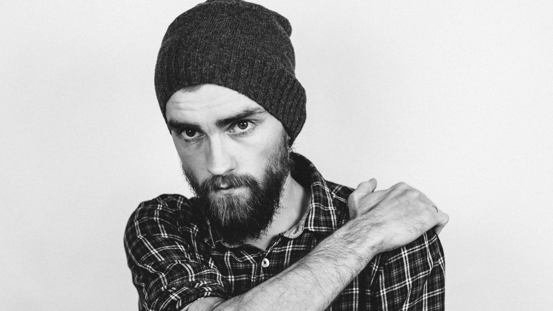 Бородатый мужчина в шапке на белом фоне 