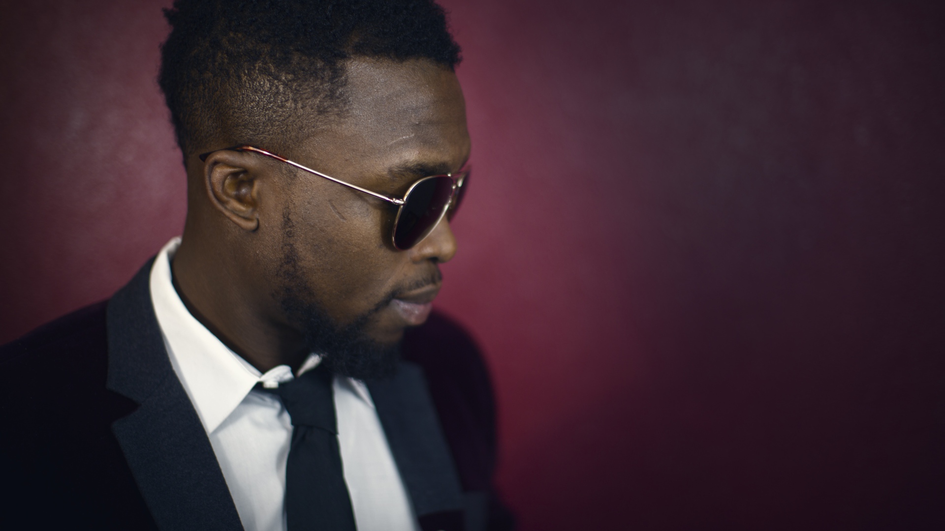 Темнокожий мужчина в костюме и очках 