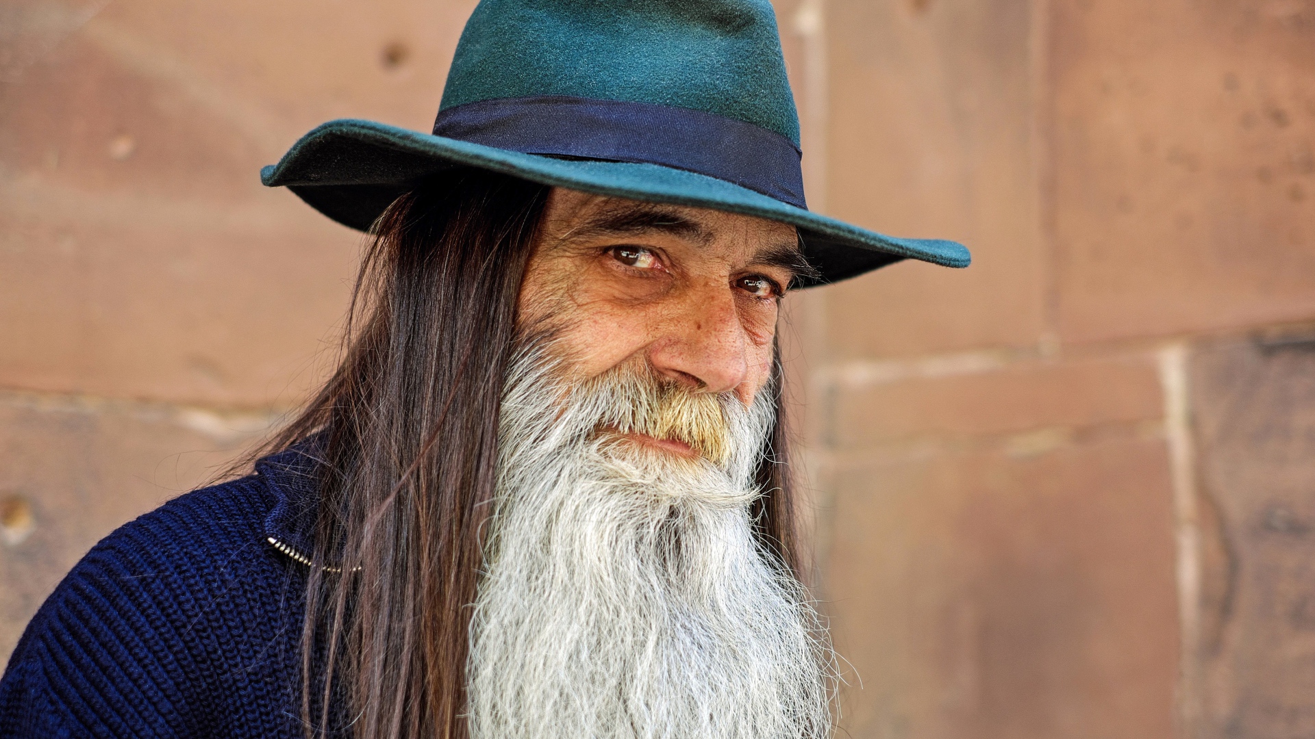 Пожилой мужчина с длинными волосами в шляпе 