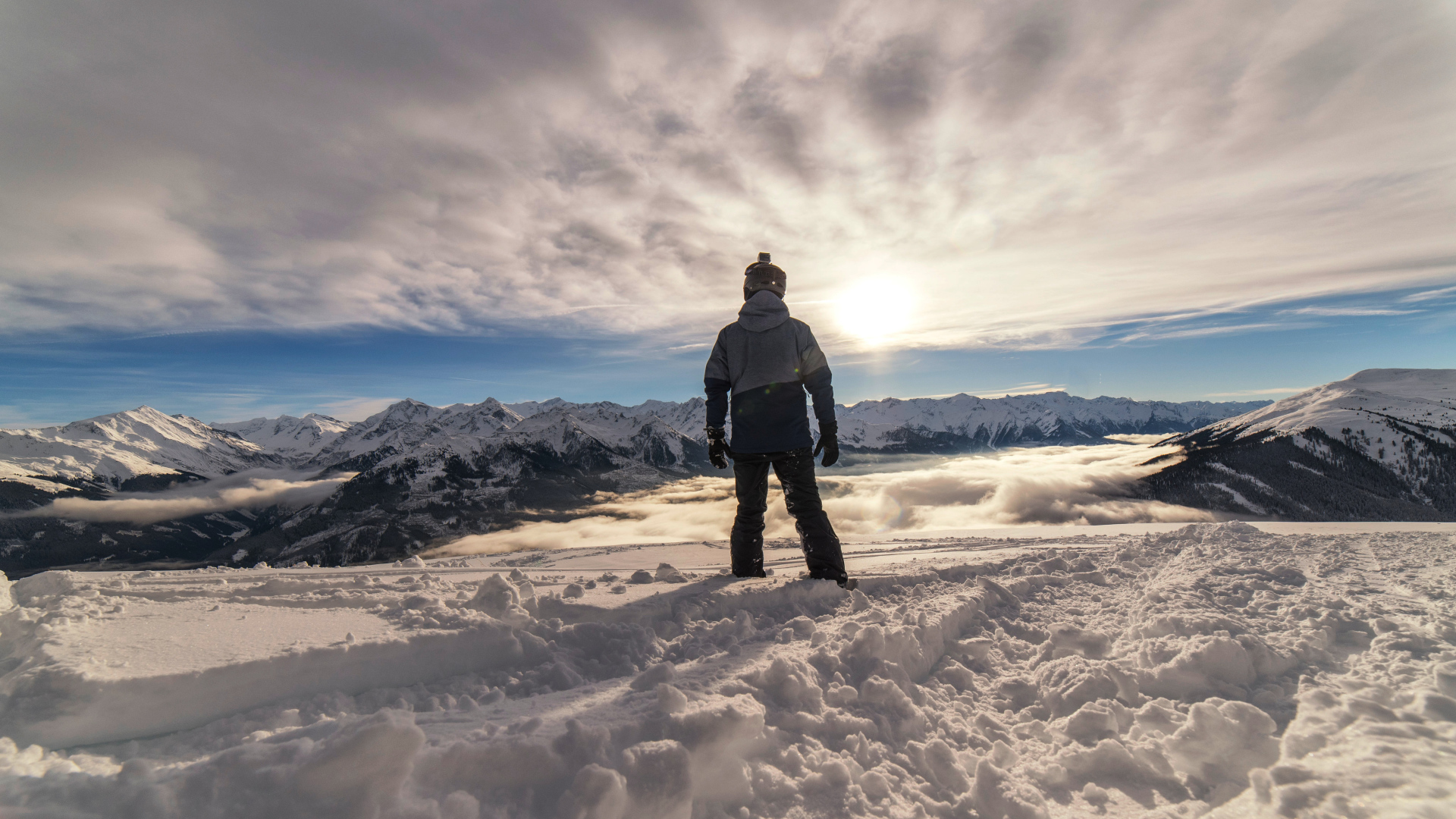 Человек в заснеженных горах в лучах солнца