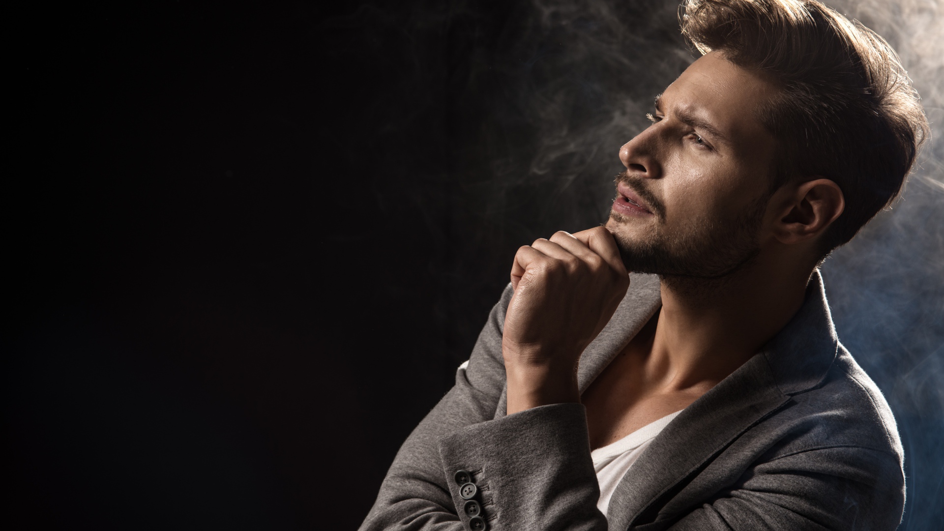 Задумчивый взгляд мужчины на черном фоне 