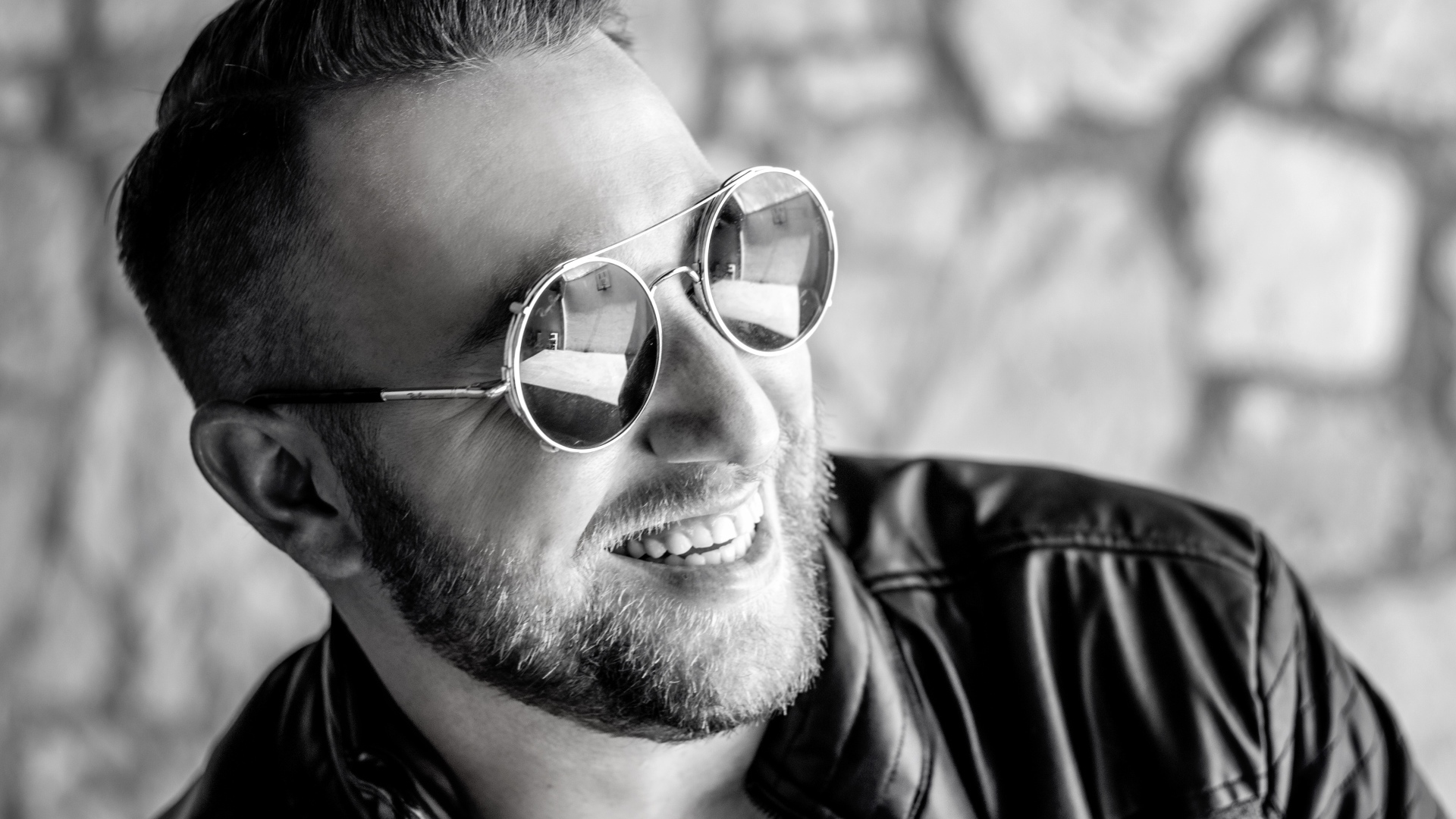 Улыбающийся брутальный мужчина в черных очках