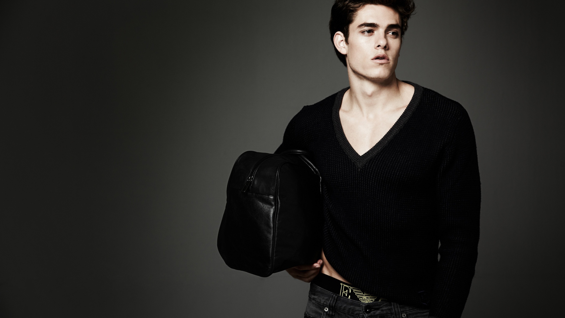 Молодой мужчина с черной сумкой в руке 