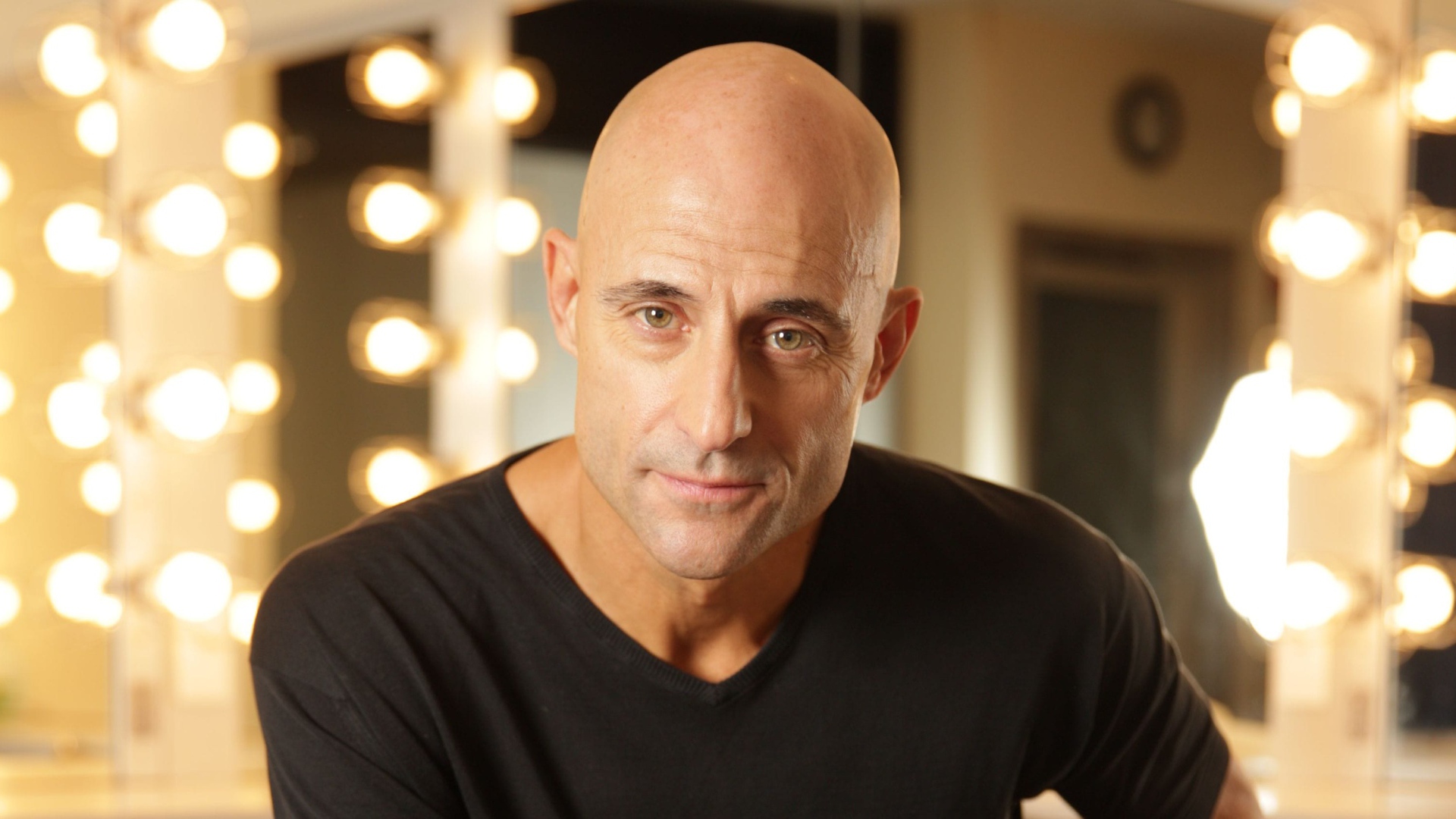 Актер Марк Стронг на фоне лампочек