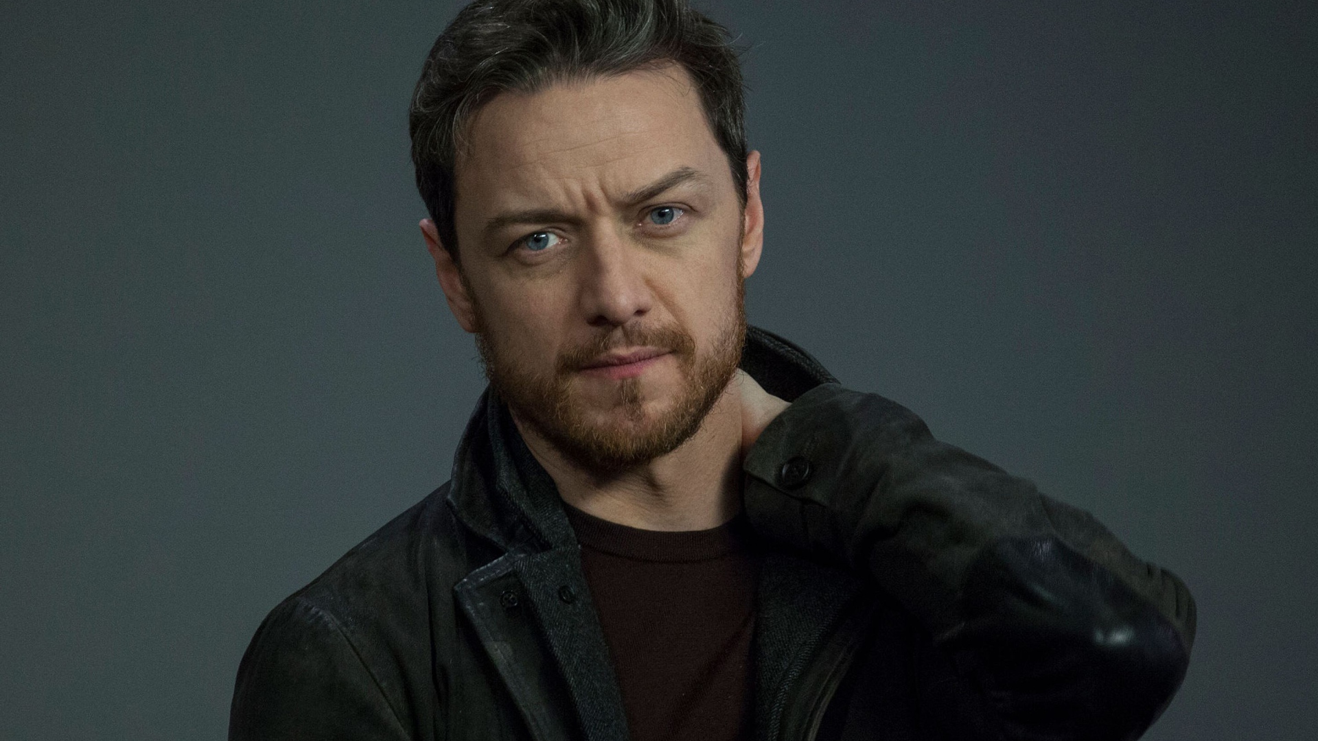 Красивый мужчина, актер Джеймс МакЭвой на сером фоне