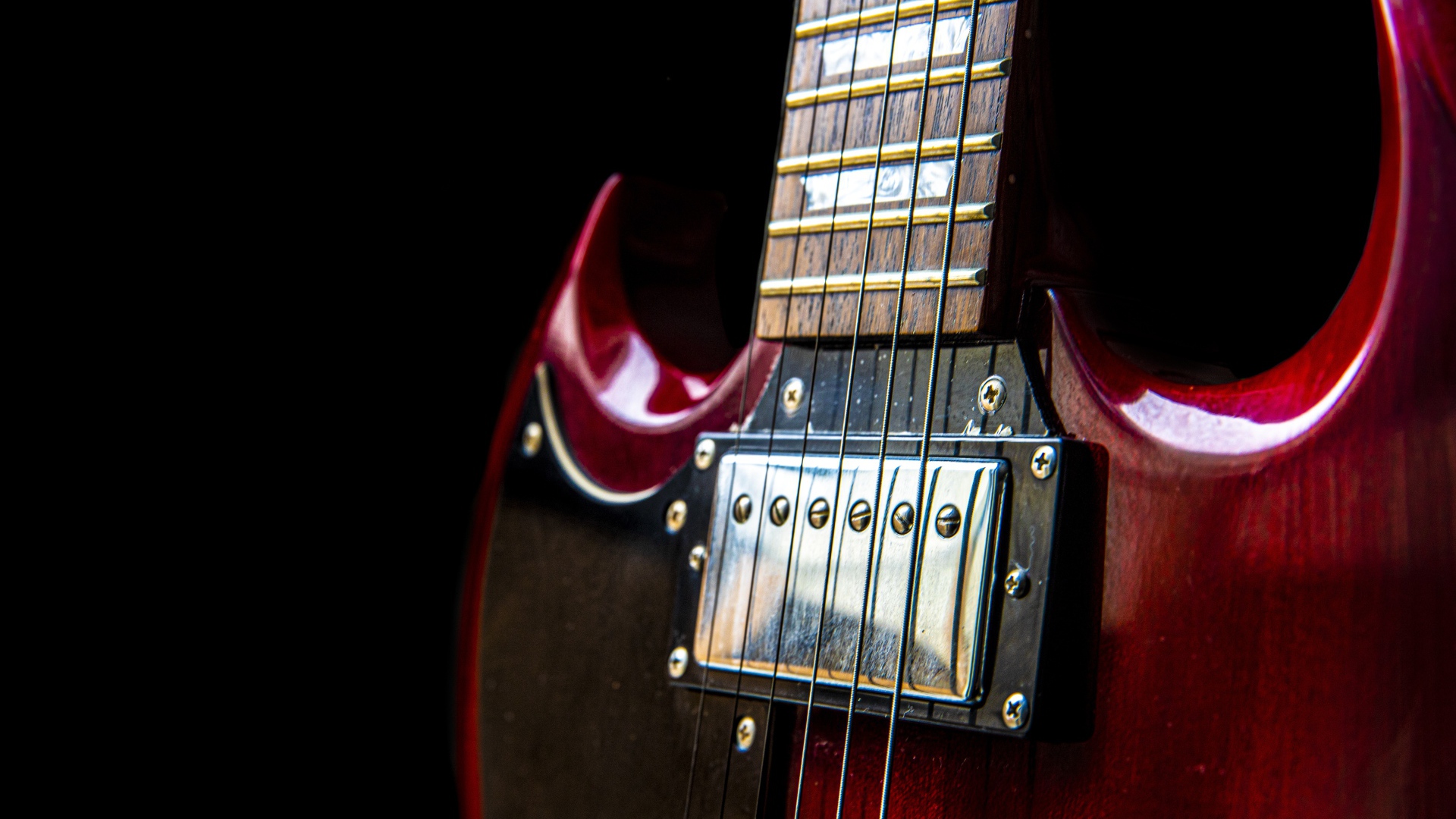 Красная гитара со струнами на черном фоне 