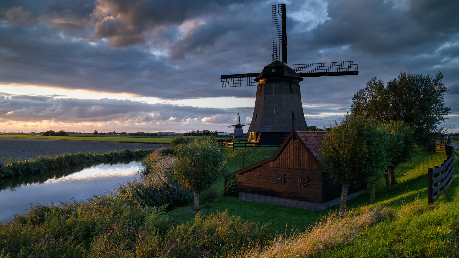 Large windmill by the river at sunset