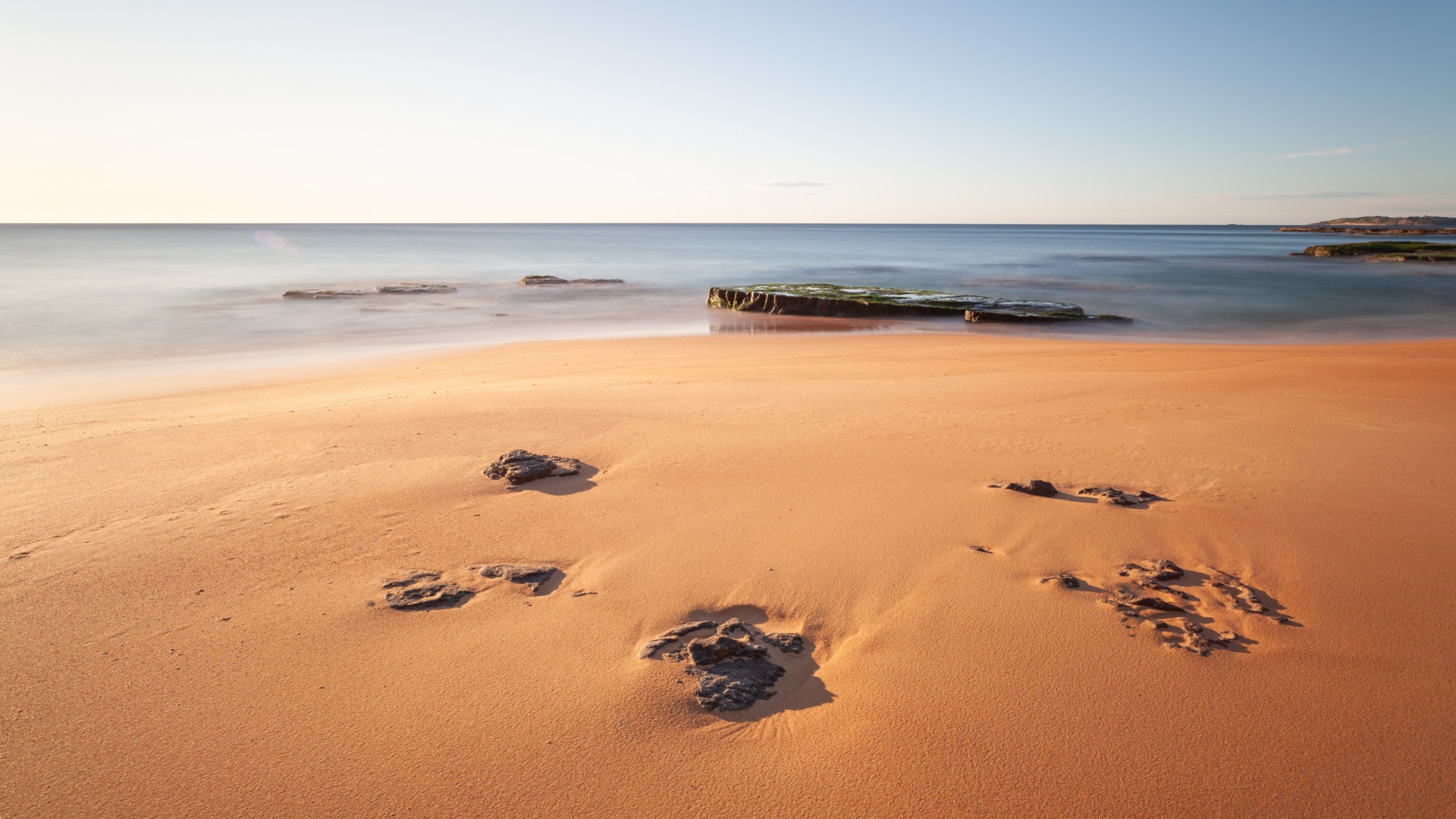 Камни в песке на берегу моря 