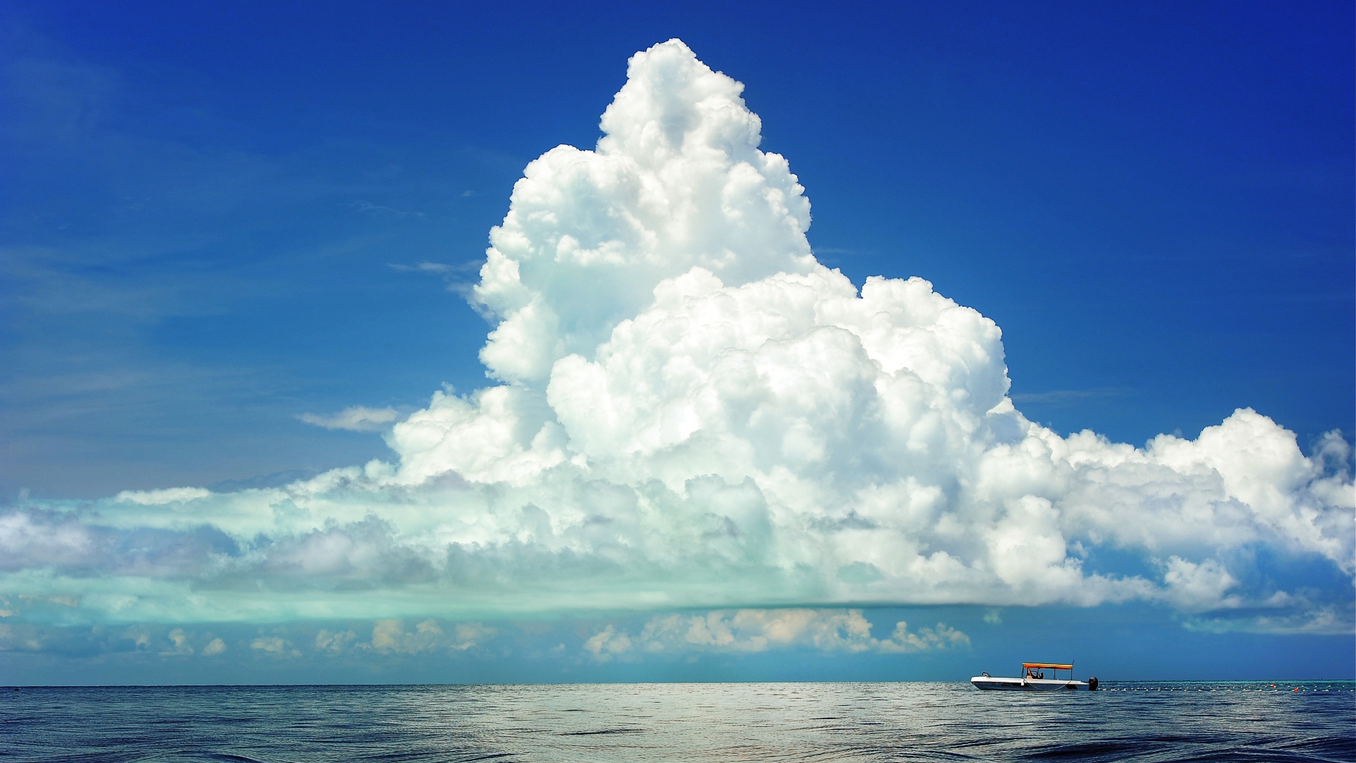Large white cloud in the blue sky over the sea