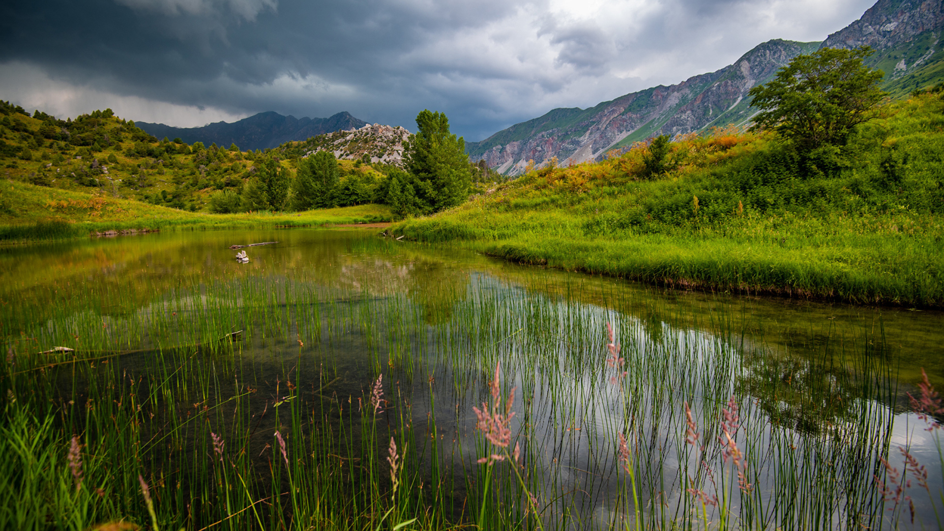 Грозовые облака над рекой в горах 