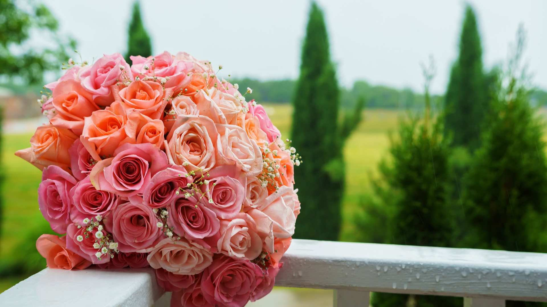 Красивый свадебный букет розовых роз на белых перилах