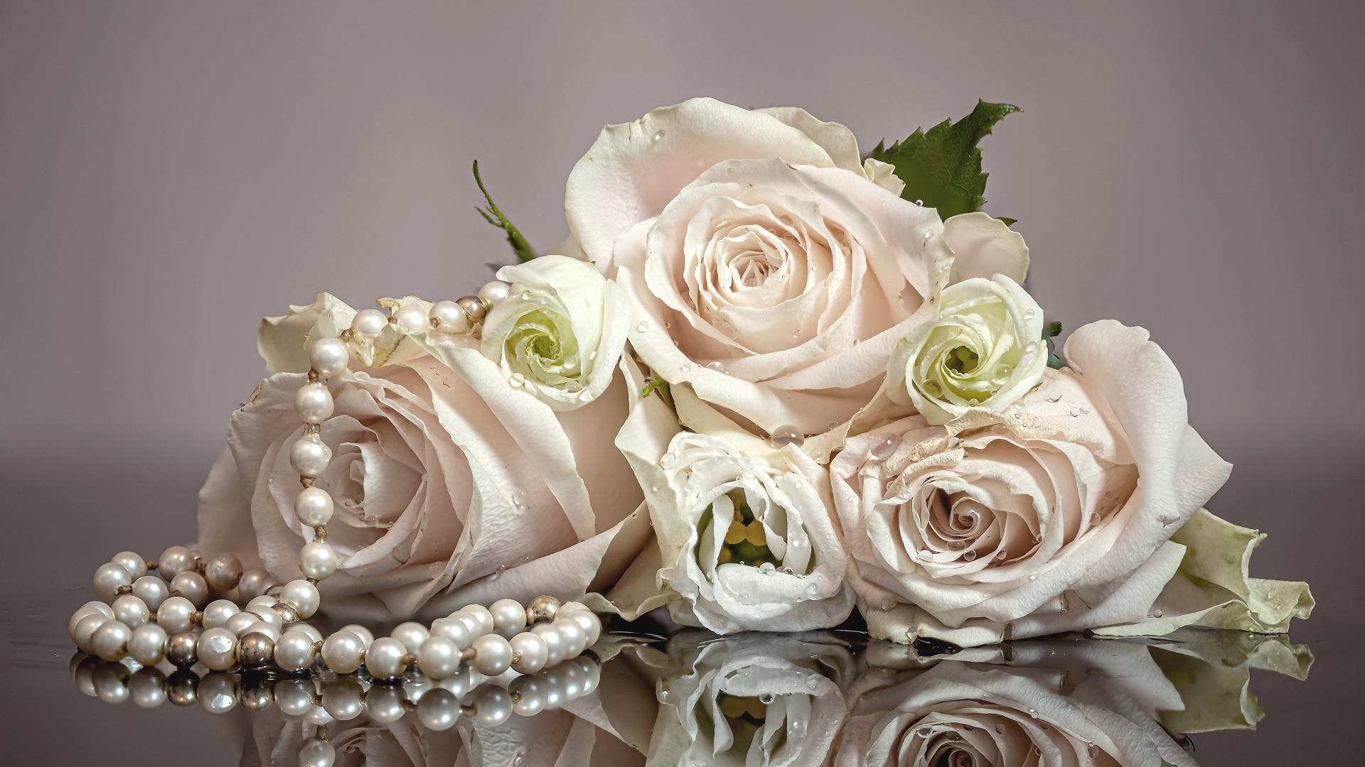 Букет белых роз с бусами на сером фоне