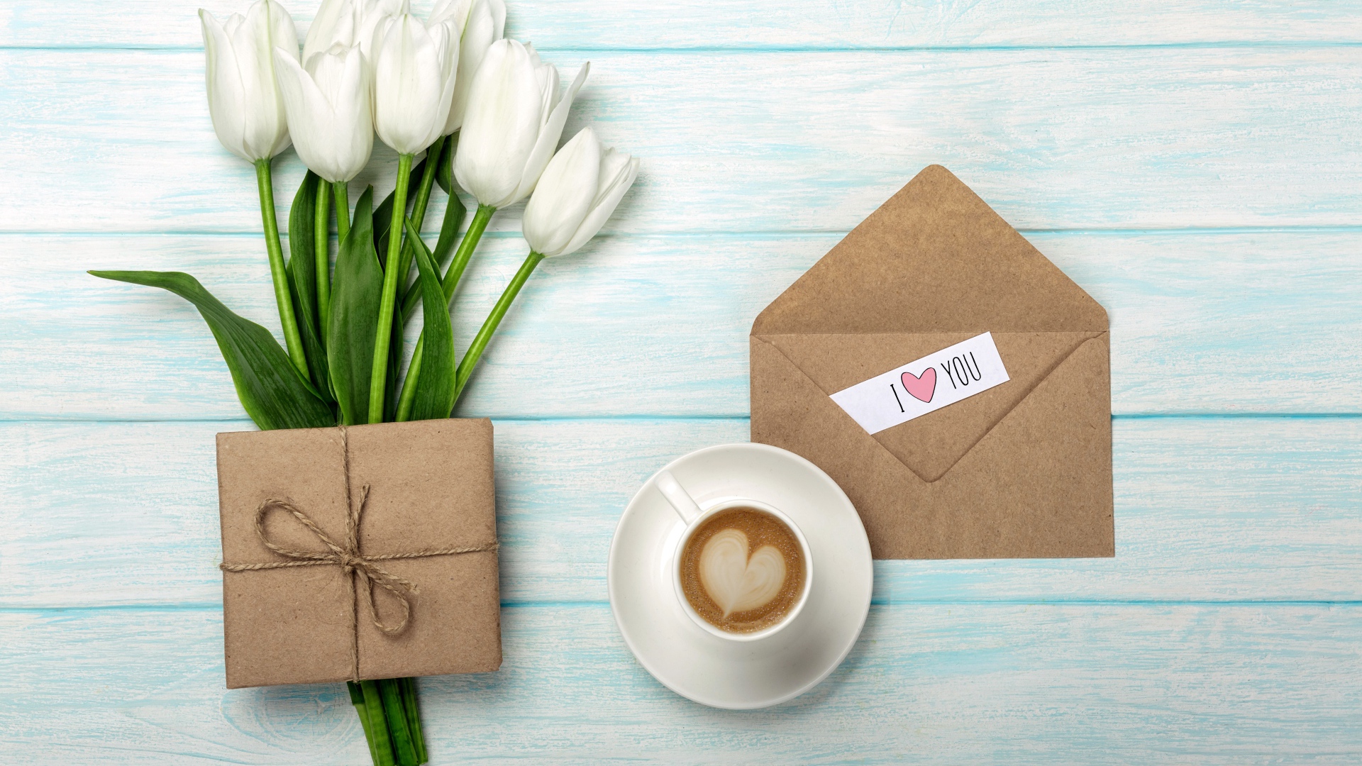 Букет белых тюльпанов на столе с подарком и чашкой кофе