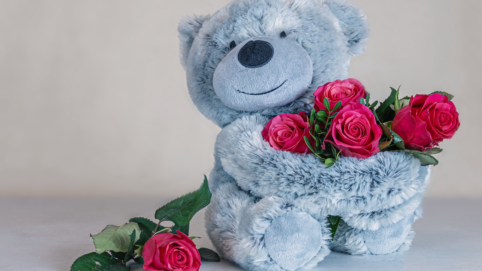Серый медвежонок с букетом роз