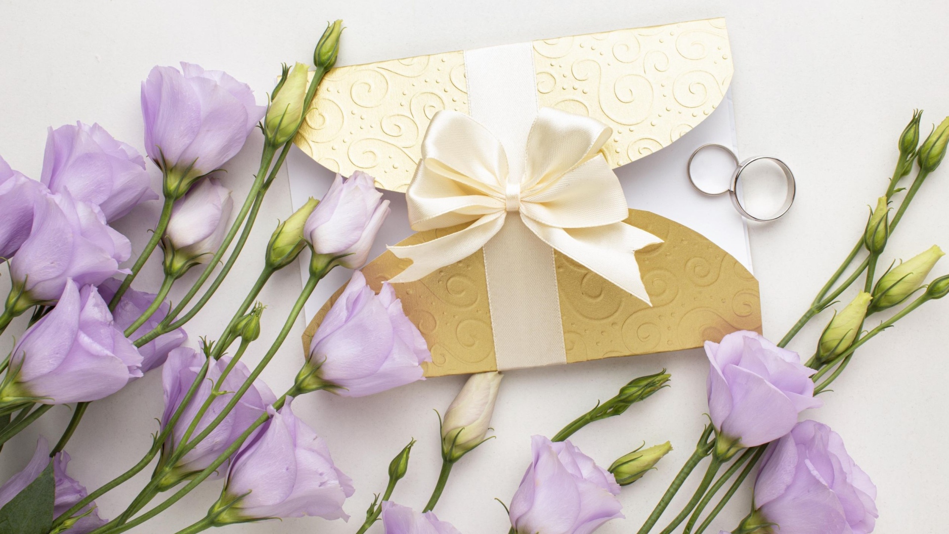 Фиолетовые цветы эустома с приглашением и обручальными кольцами