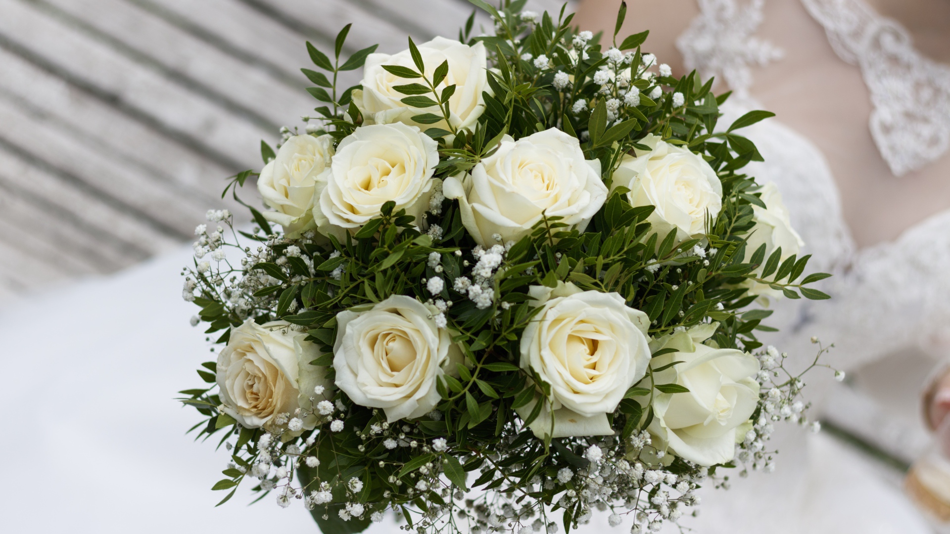 Свадебный букет белых роз в руке у невесты