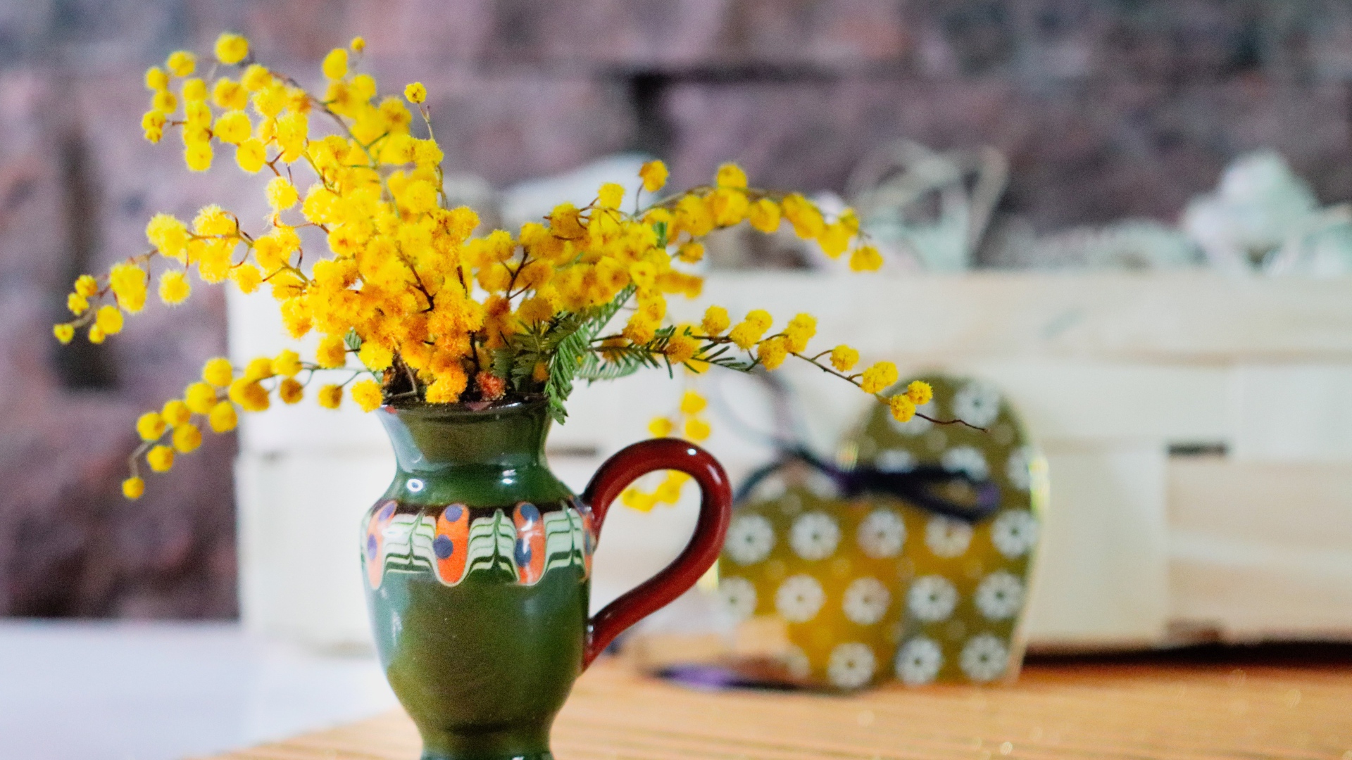 Желтые цветы мимозы в маленькой вазе на столе