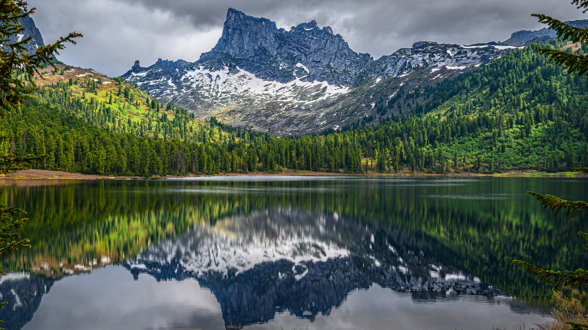 Красивая гора под грозовым небом отражается в озере 