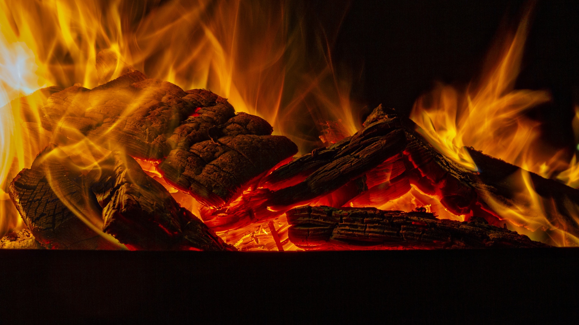 Дрова горят желтым пламенем в камине
