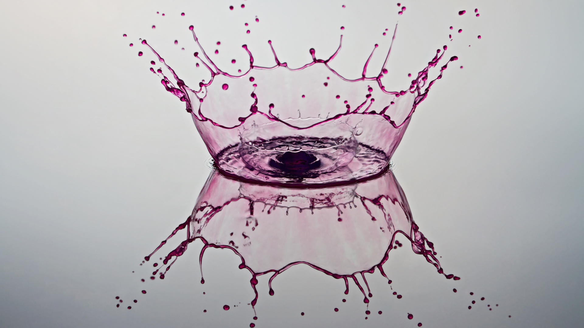 Брызги фиолетовой краски на сером фоне 