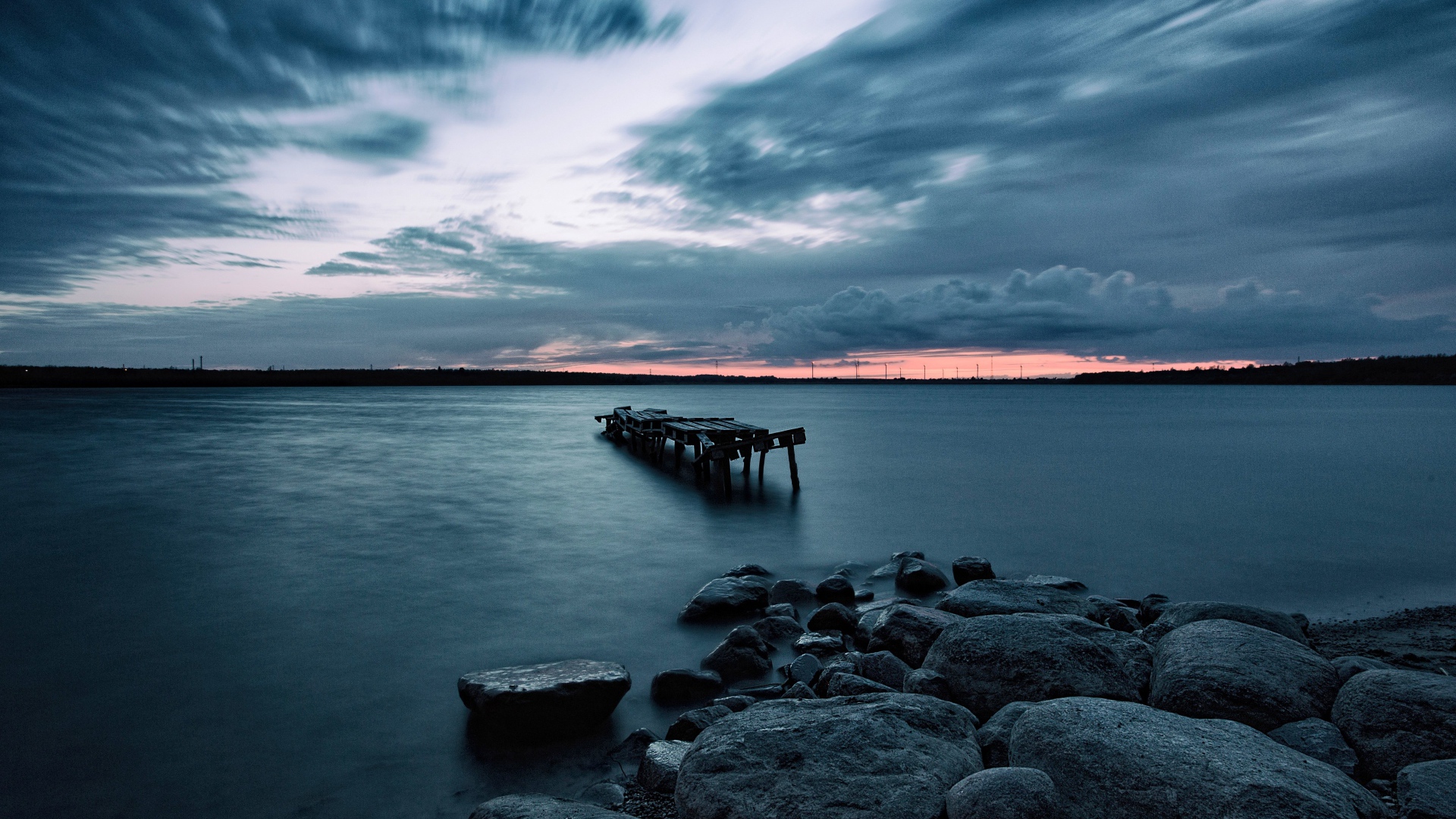Большие камни на берегу у моря в сумерках 