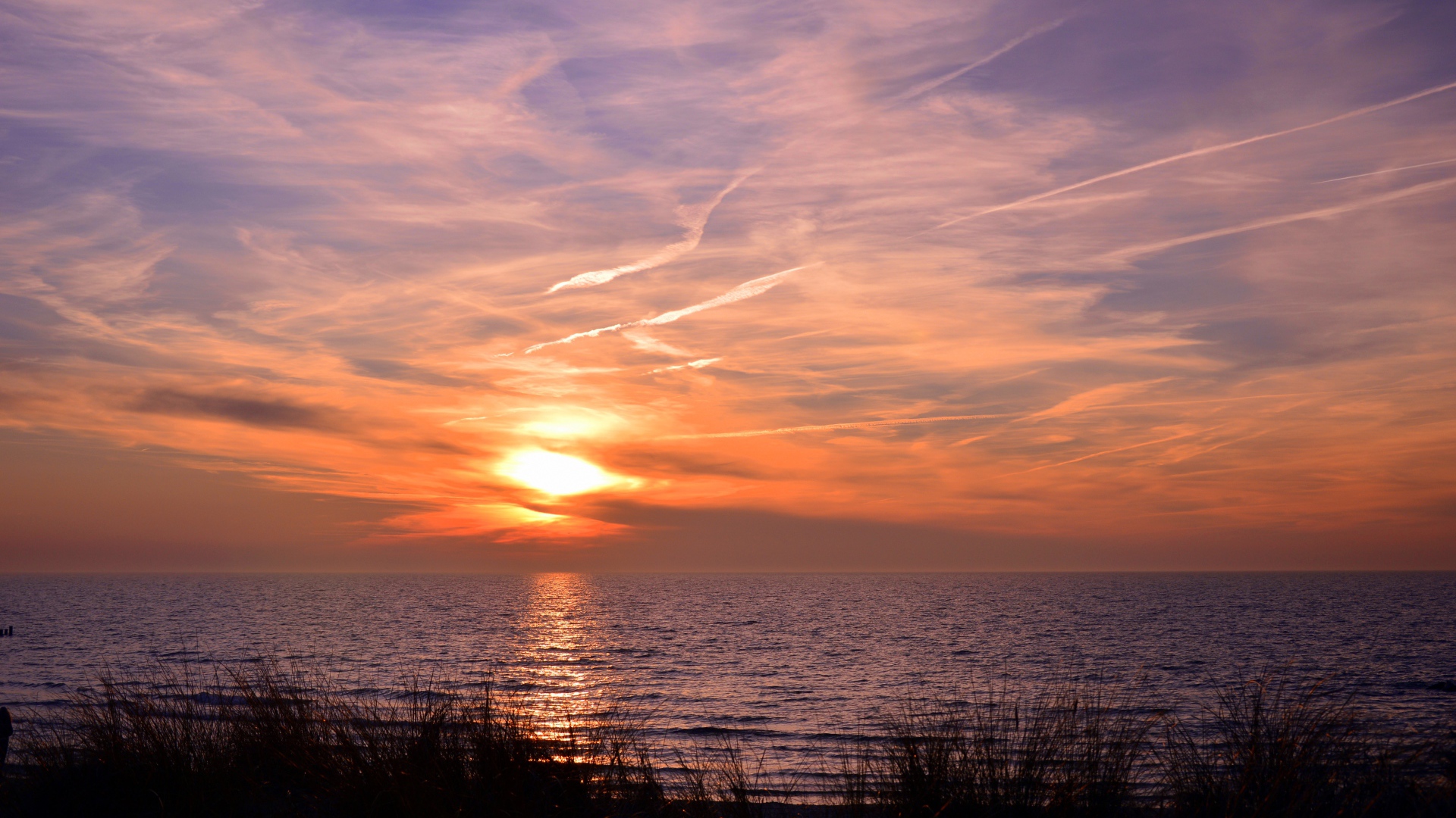 Закат солнца над спокойным озером летом