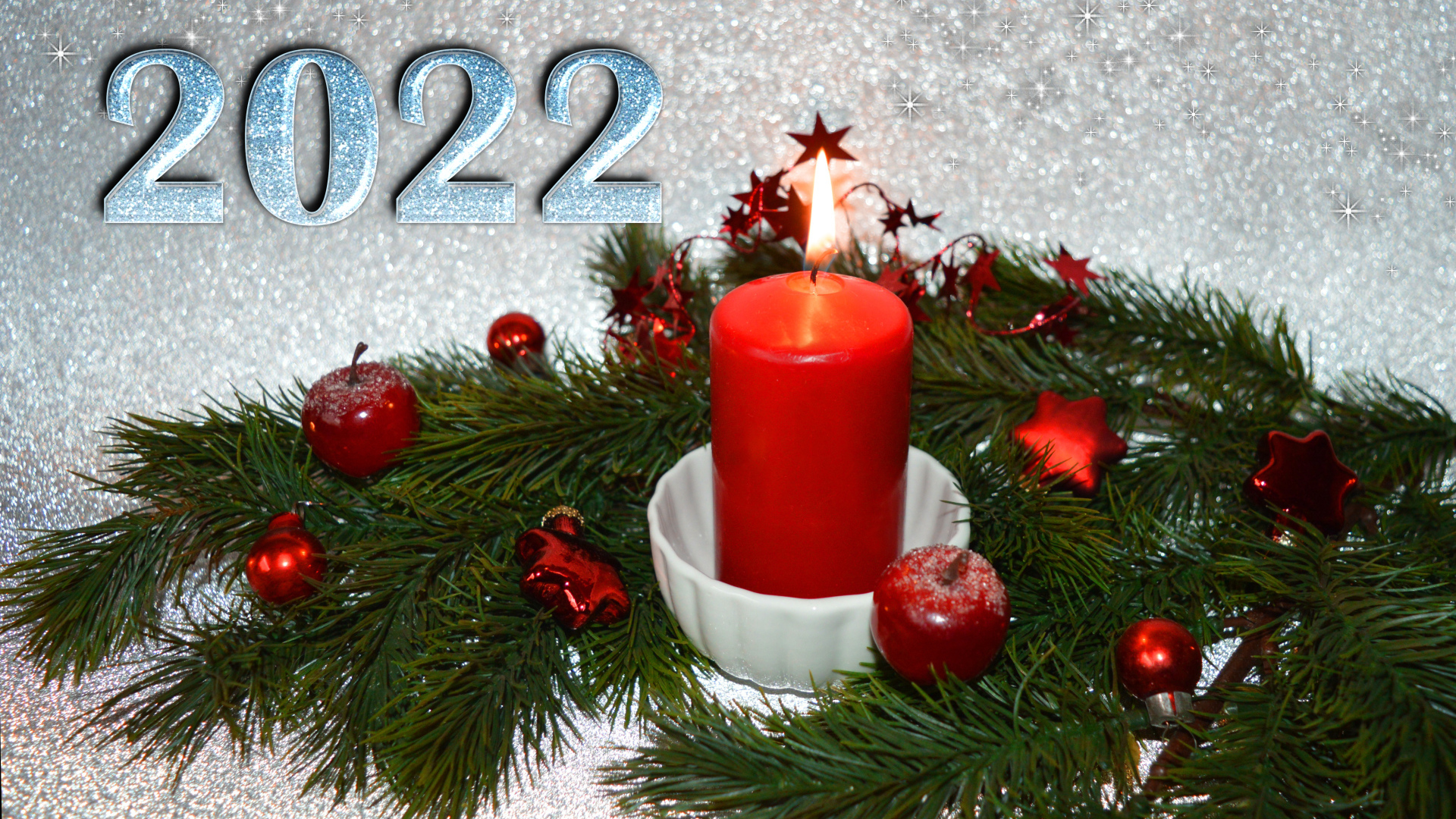 Свеча и еловая ветка с украшениями на новый год 2022