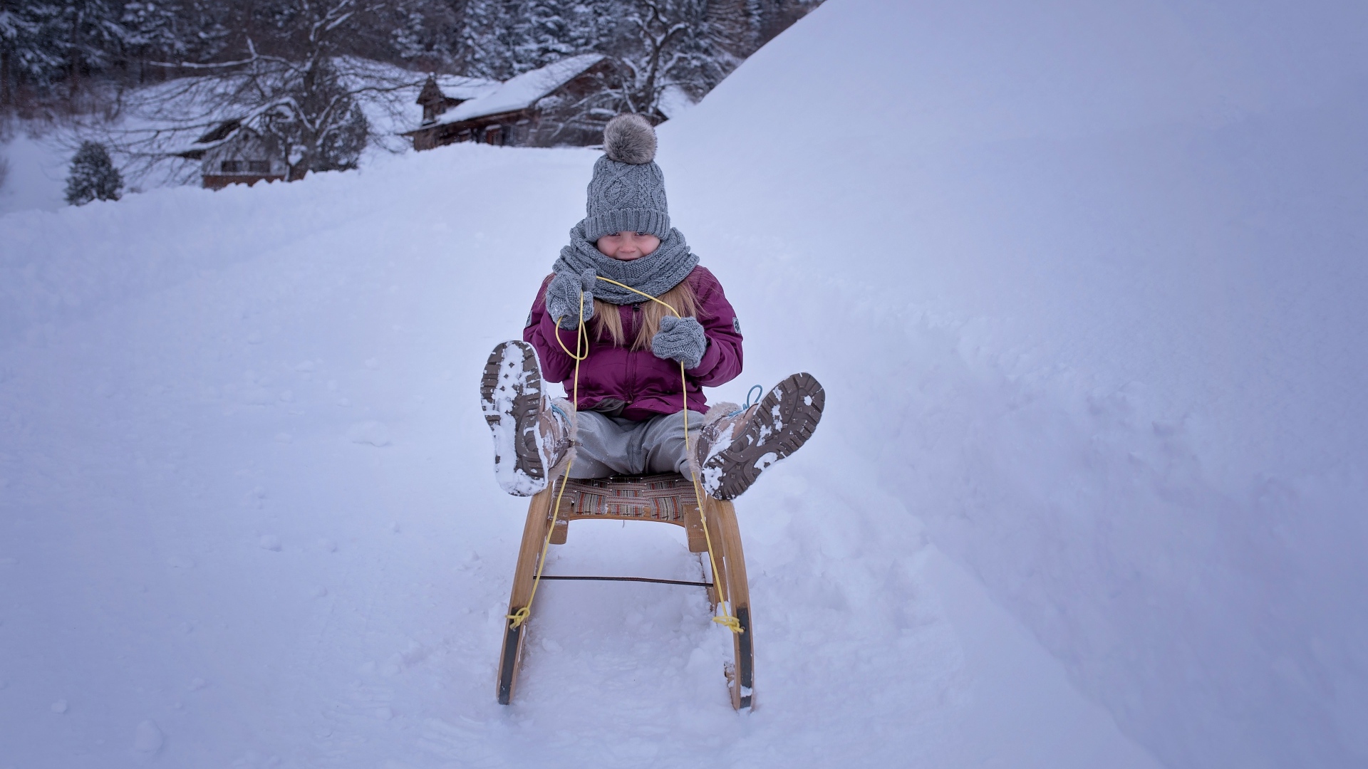 Девочка едет на санках с горки