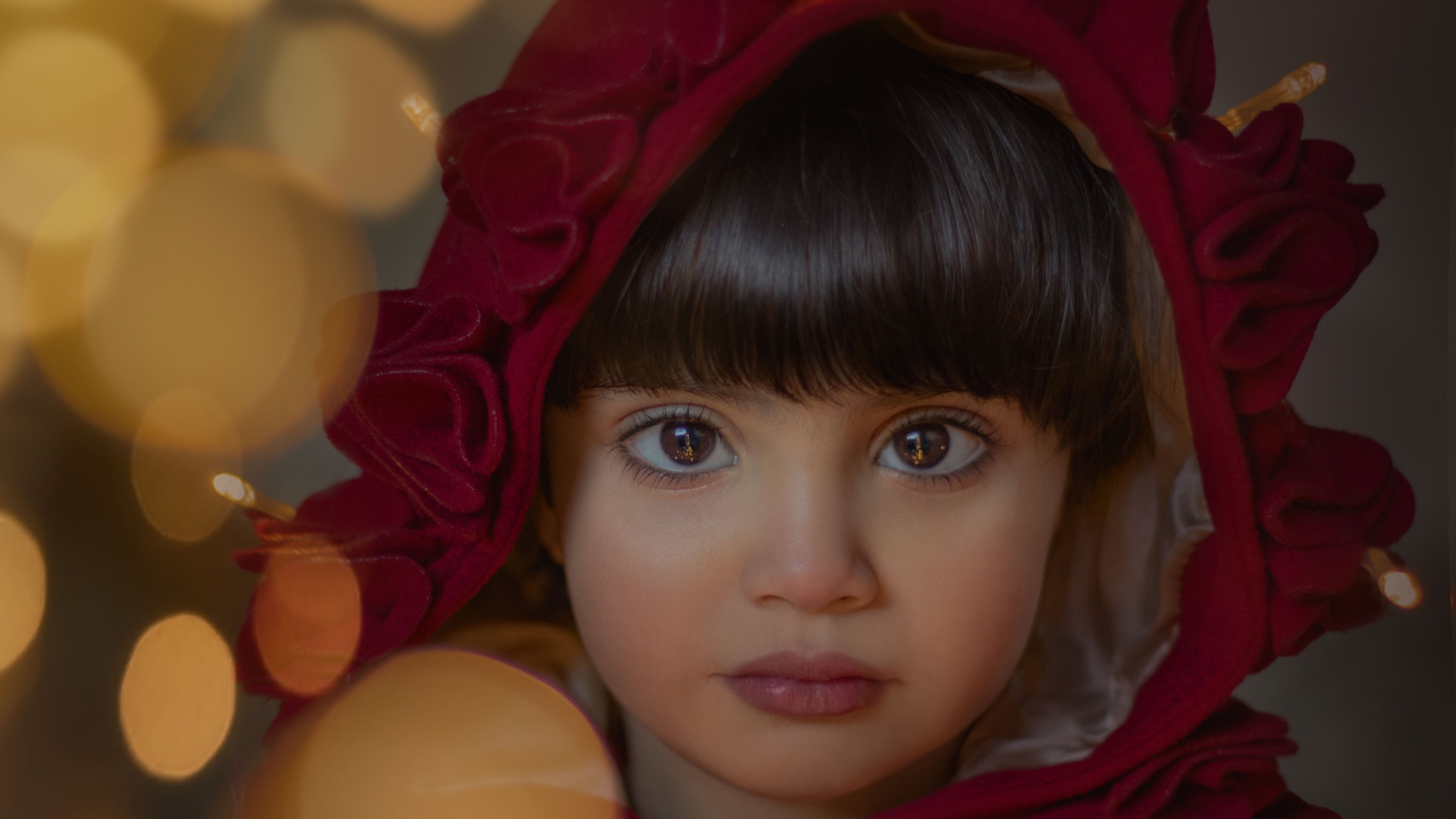 Девочка с большими карими глазами в красном капюшоне