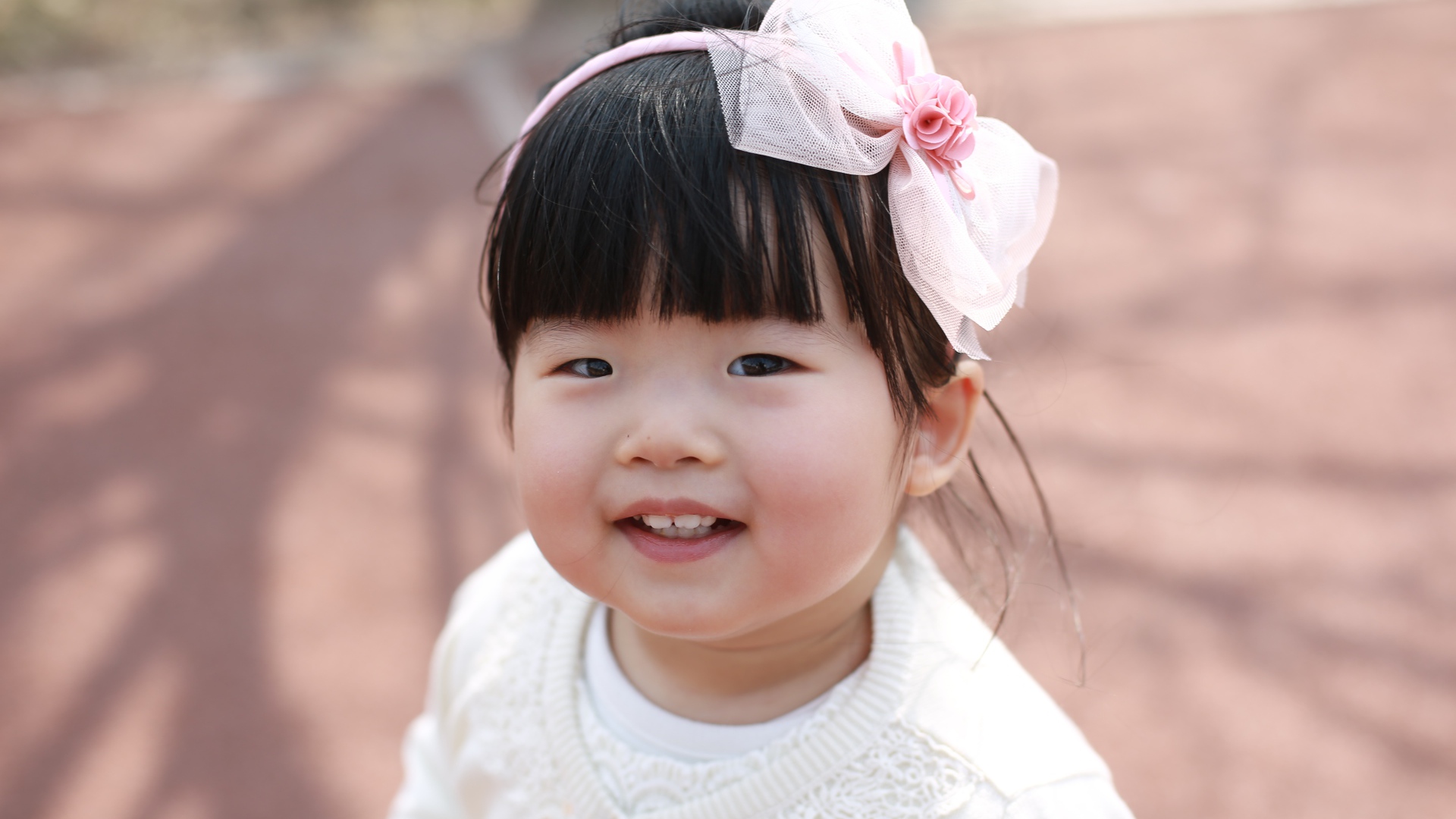 Маленькая девочка азиатка с бантом на голове 