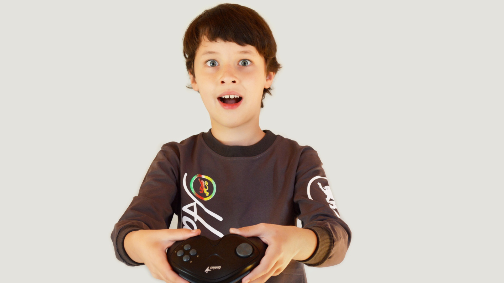 Маленький мальчик с приставкой на сером фоне 