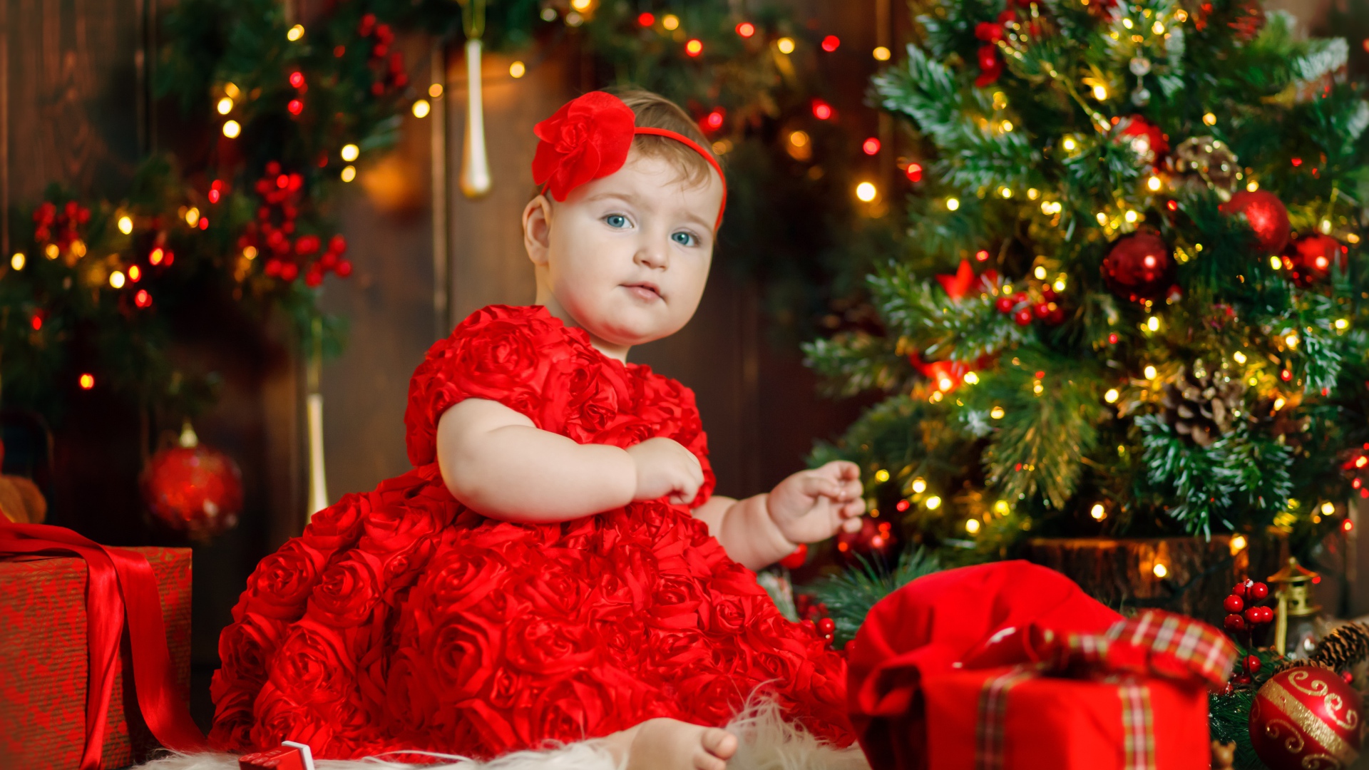 Маленькая девочка в красивом платье у наряженной ели 