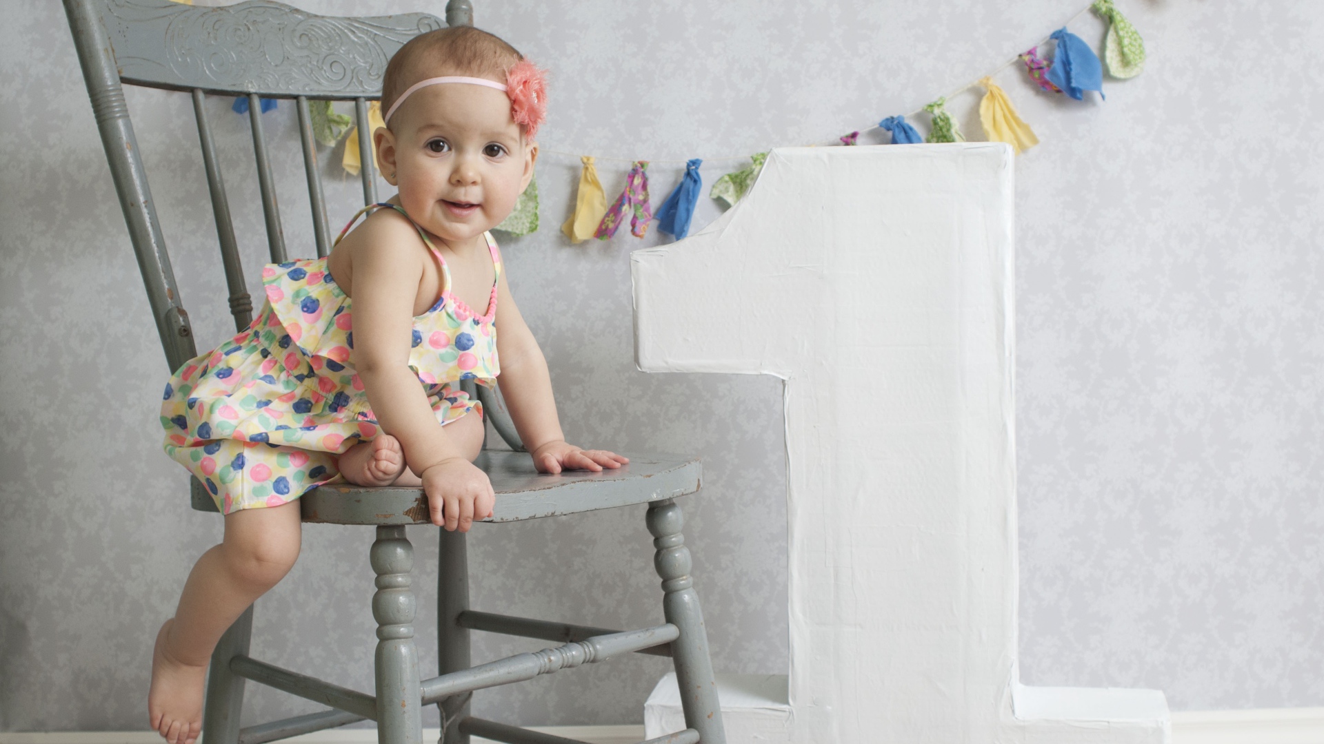 Маленькая девочка в платье на стуле