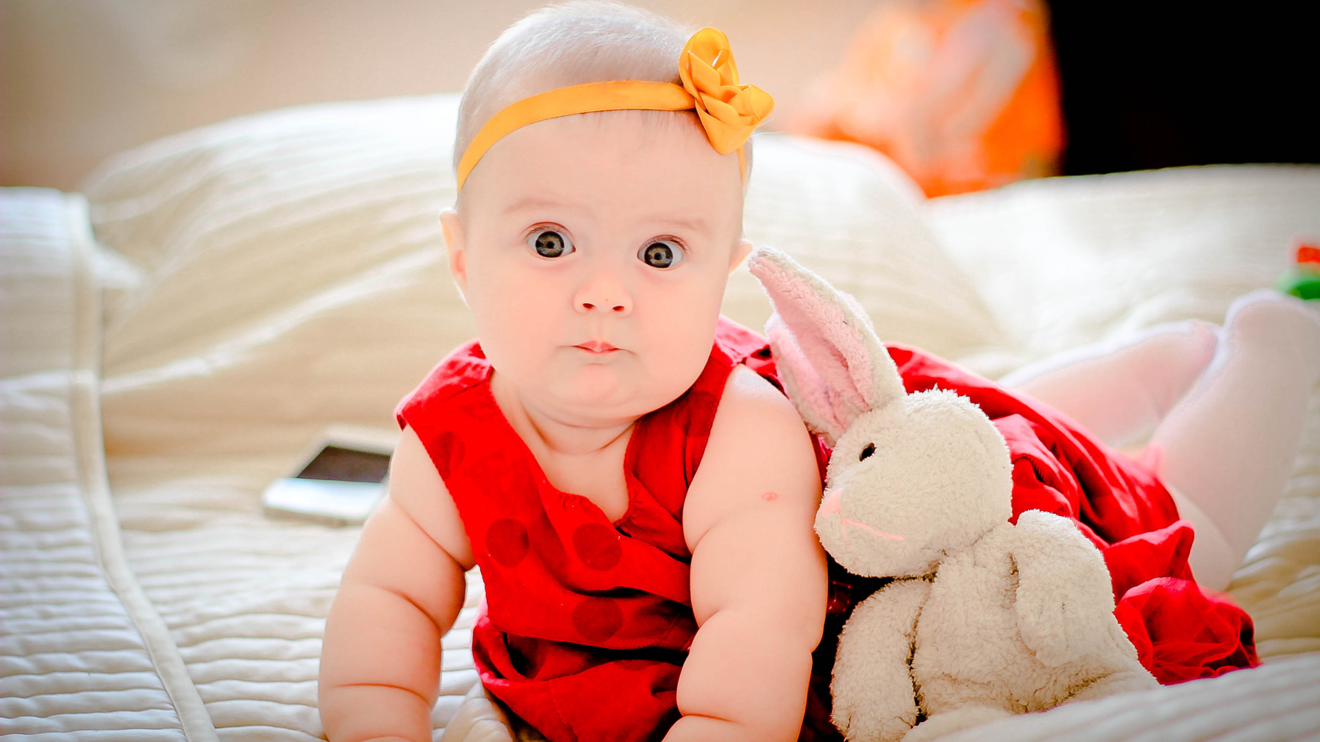 Маленькая девочка в красном платье с игрушкой 