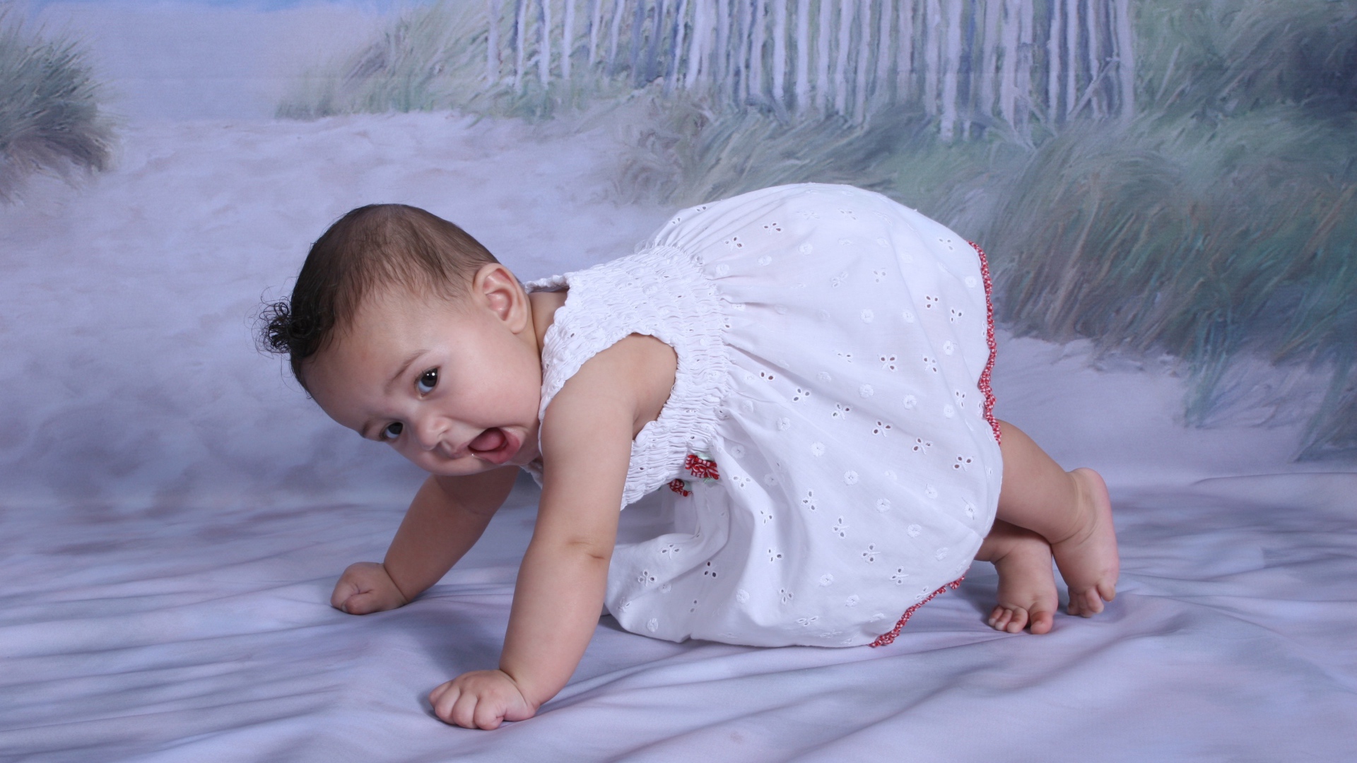 Маленькая девочка в белом платье на кровати 