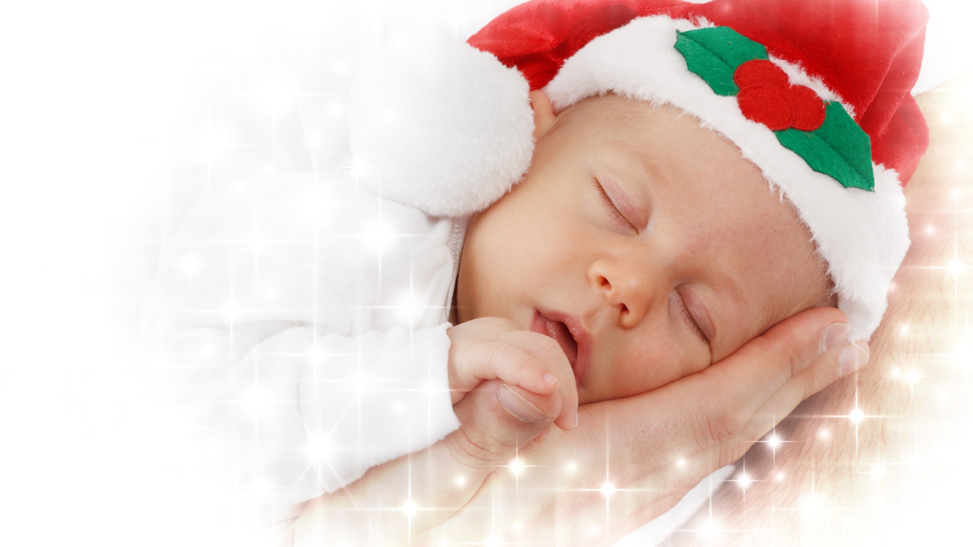 Маленький спящий ребенок в новогодней шапке 
