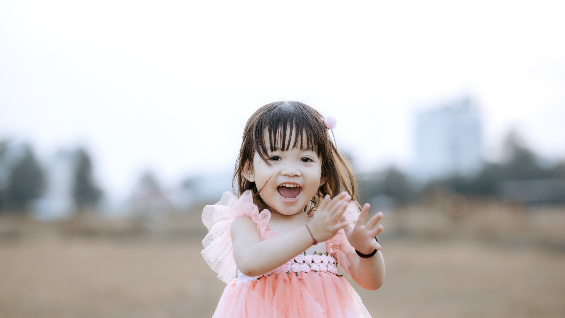 Довольная маленькая девочка в розовом платье 