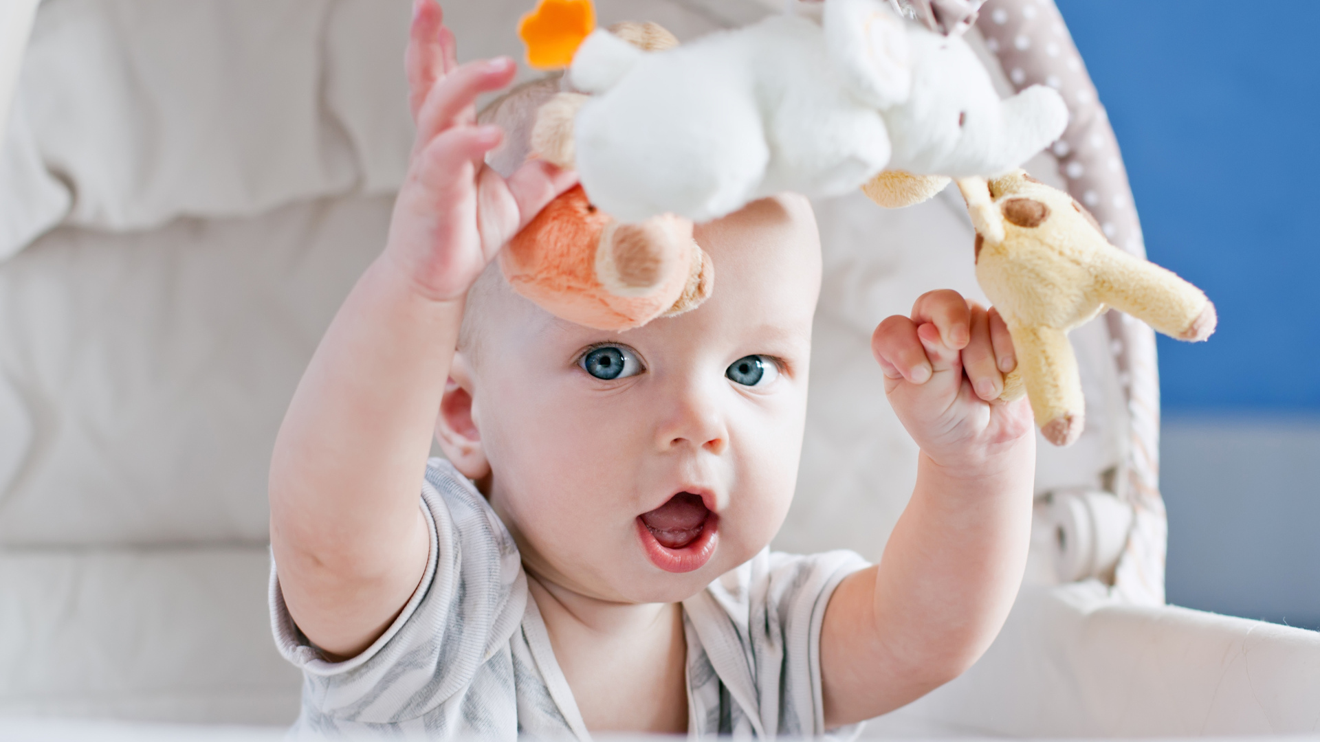 Маленький грудной ребенок в коляске с игрушками 