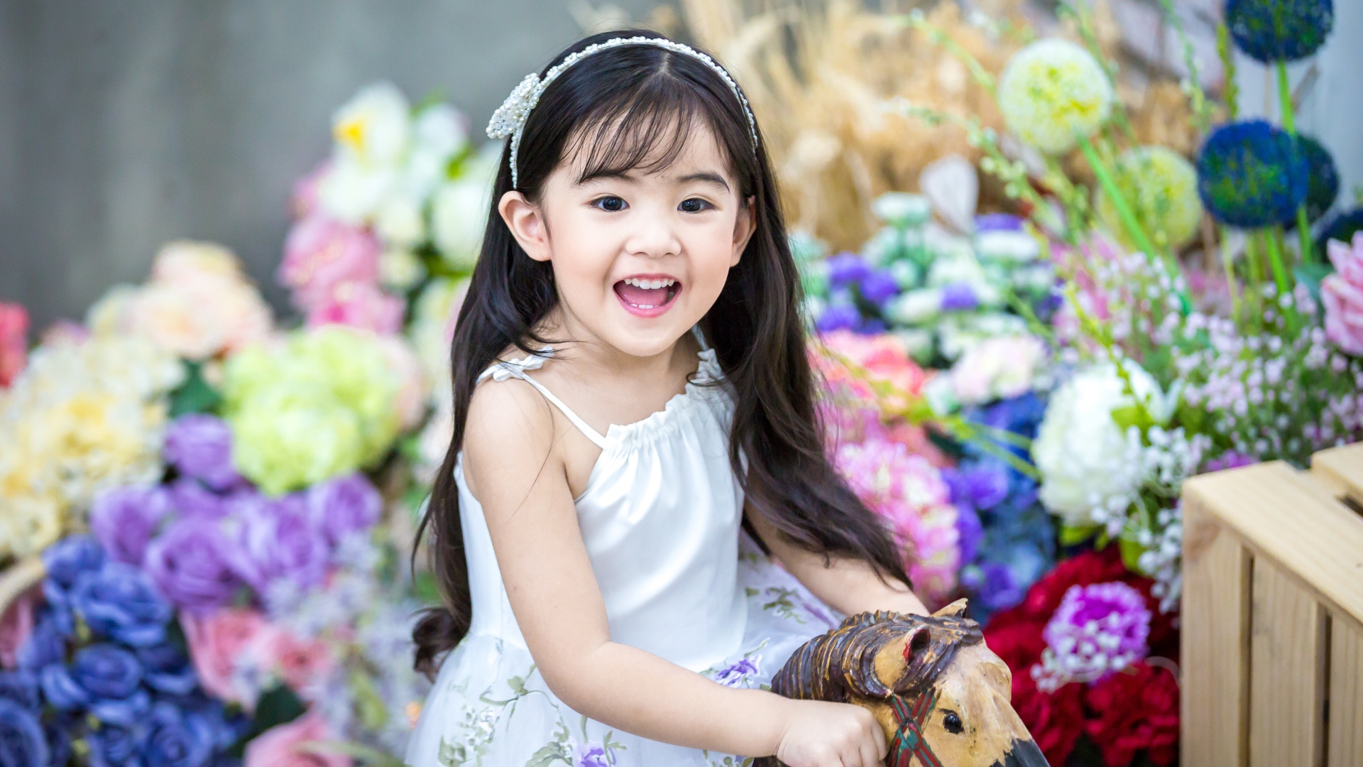 Улыбающаяся маленькая девочка азиатка на лошадке