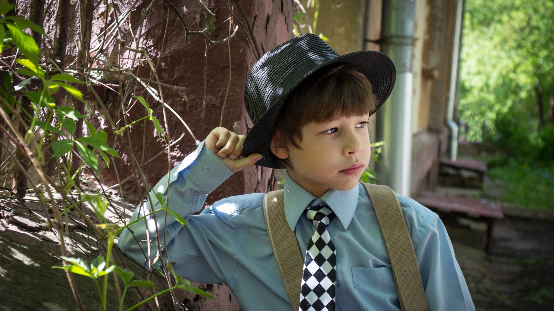 Стильный мальчик в черной шляпе 