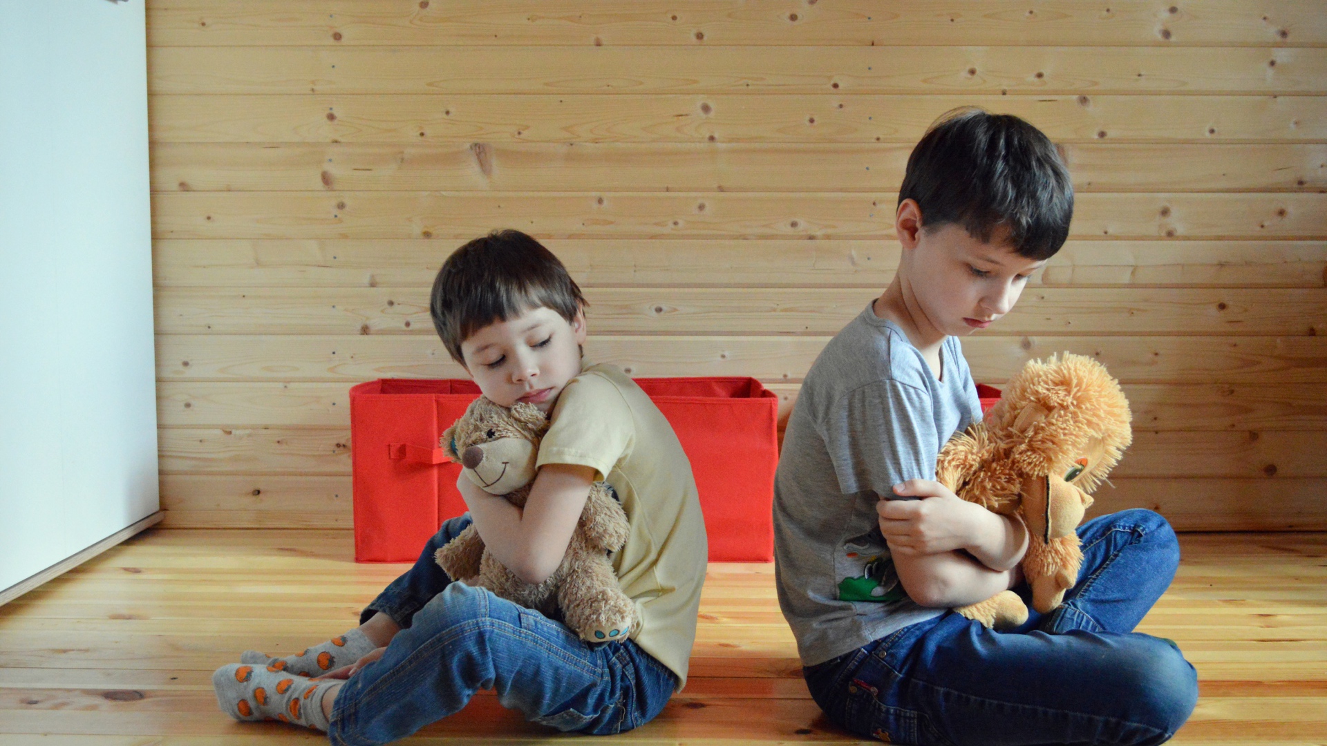 Два маленьких обиженных мальчика сидит на земле