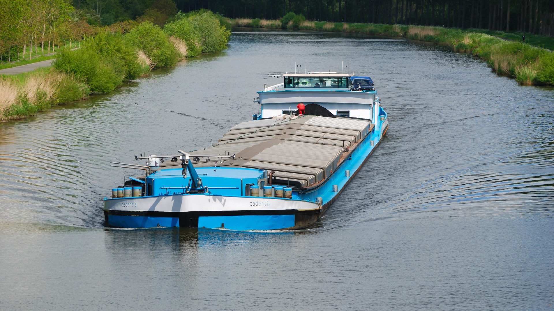 Грузовая баржа плывет по реке 