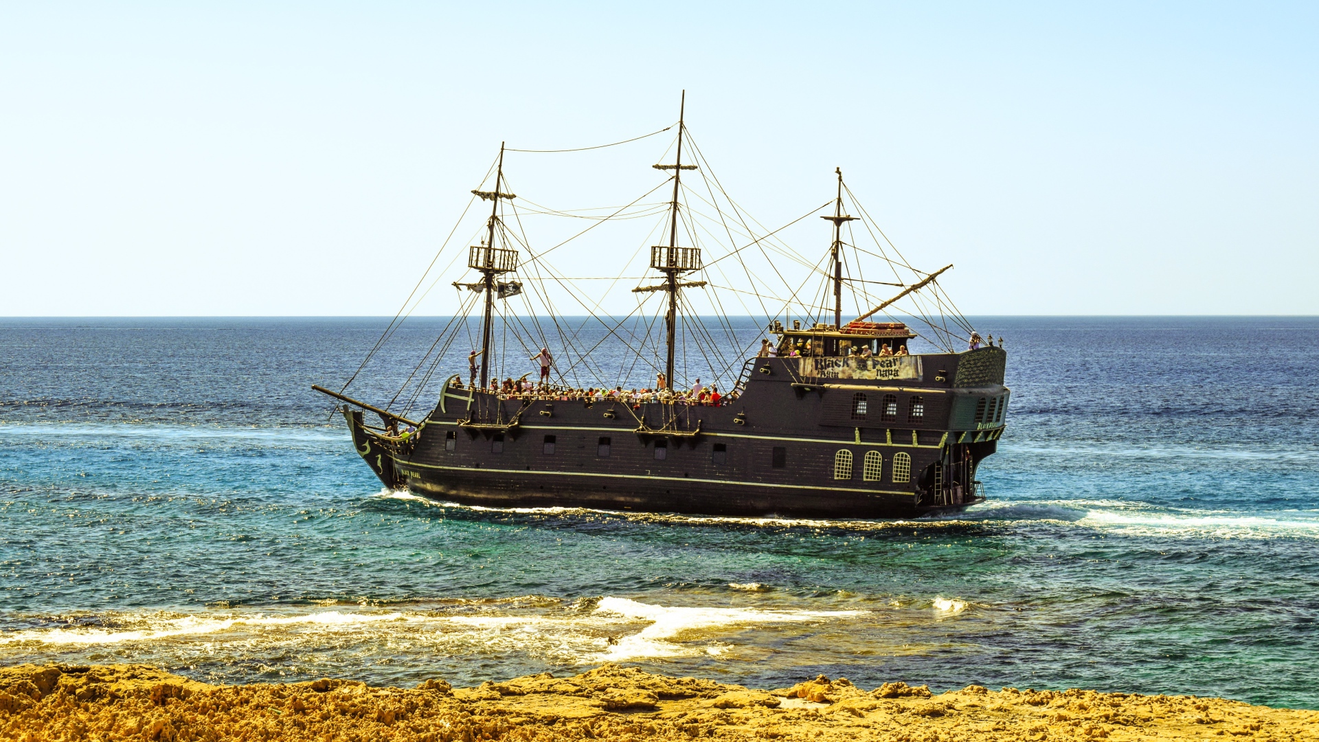 Big black pirate ship off the coast