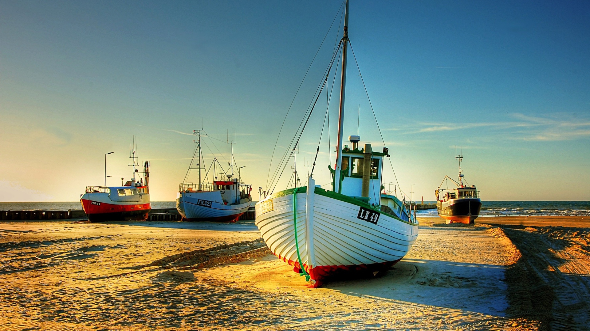 Рыболовные лодки в лучах солнца на берегу 